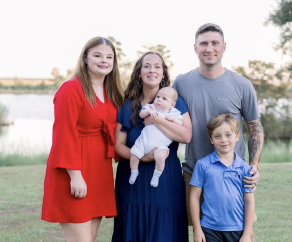 Family of five standing by the water