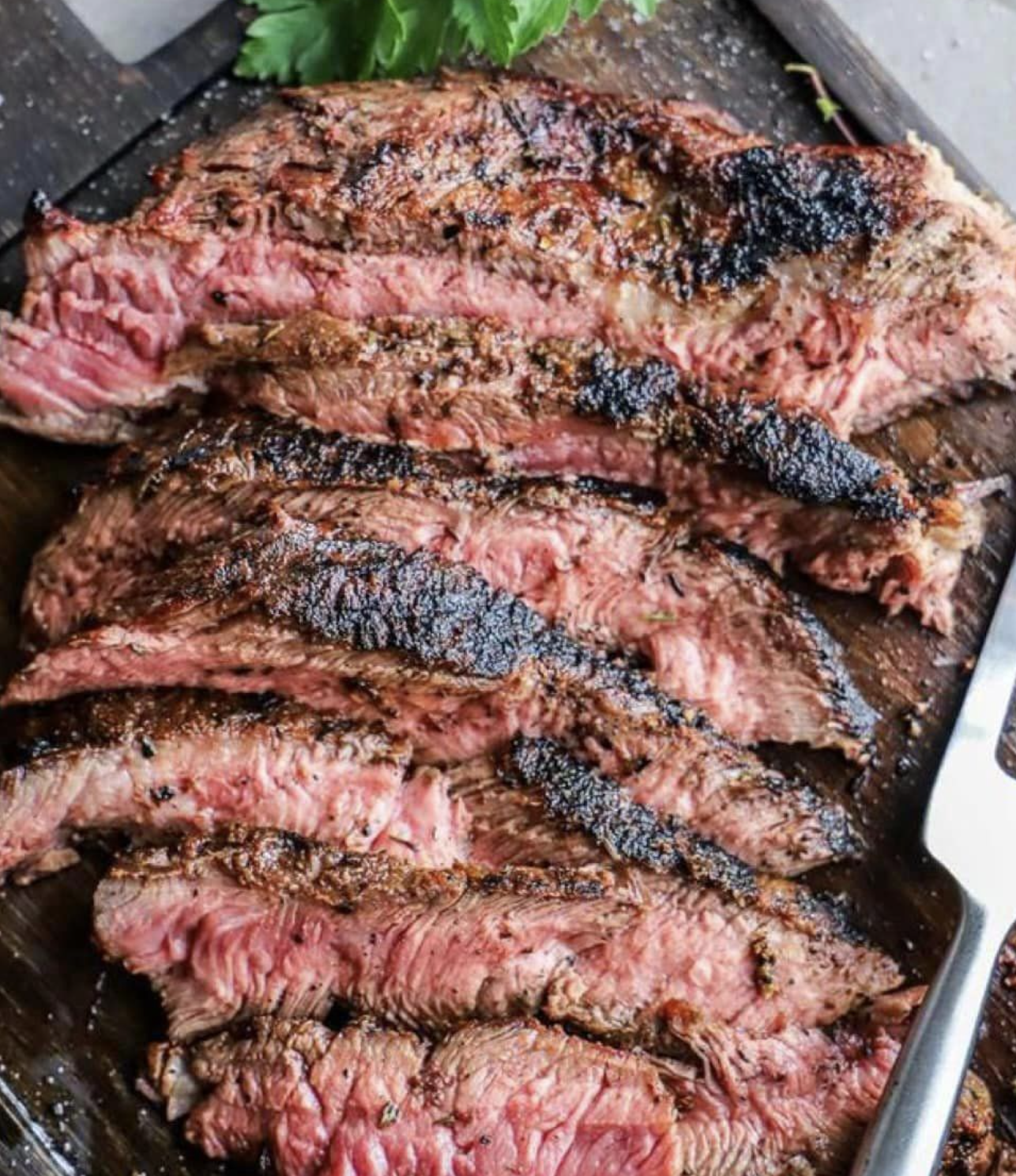 Sliced grilled steak on a cutting board, from locally raised Black Jack Ranch beef
