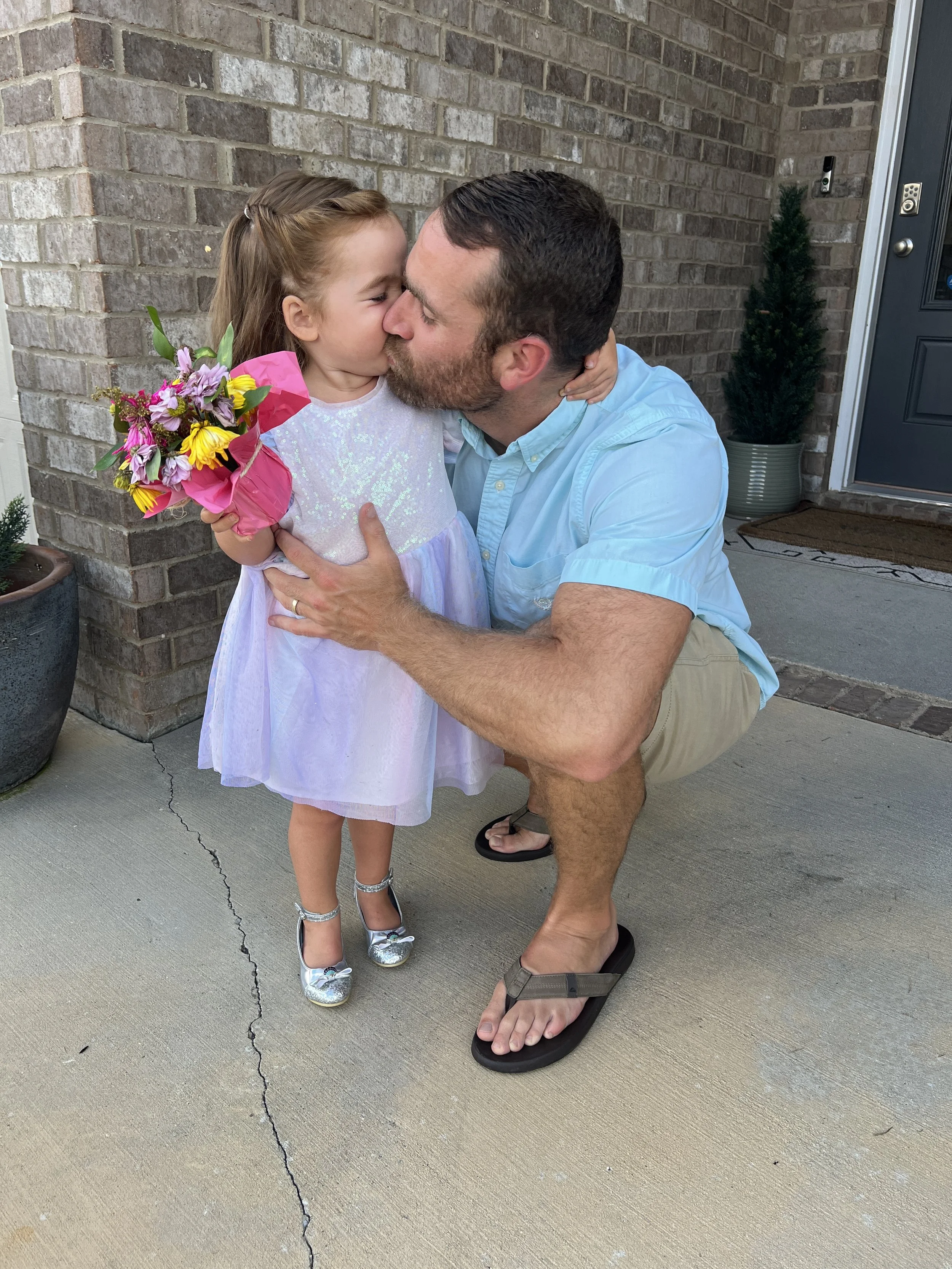 Dad kissing his daughter's cheek before a daddy-daughter date