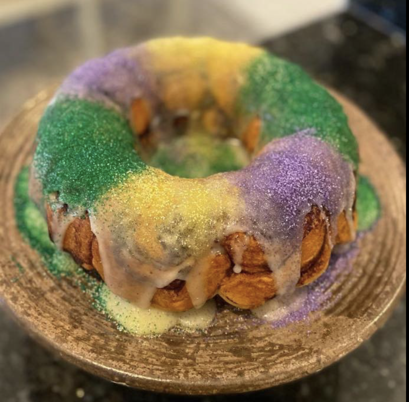 Homemade king cake with purple, green and gold icing