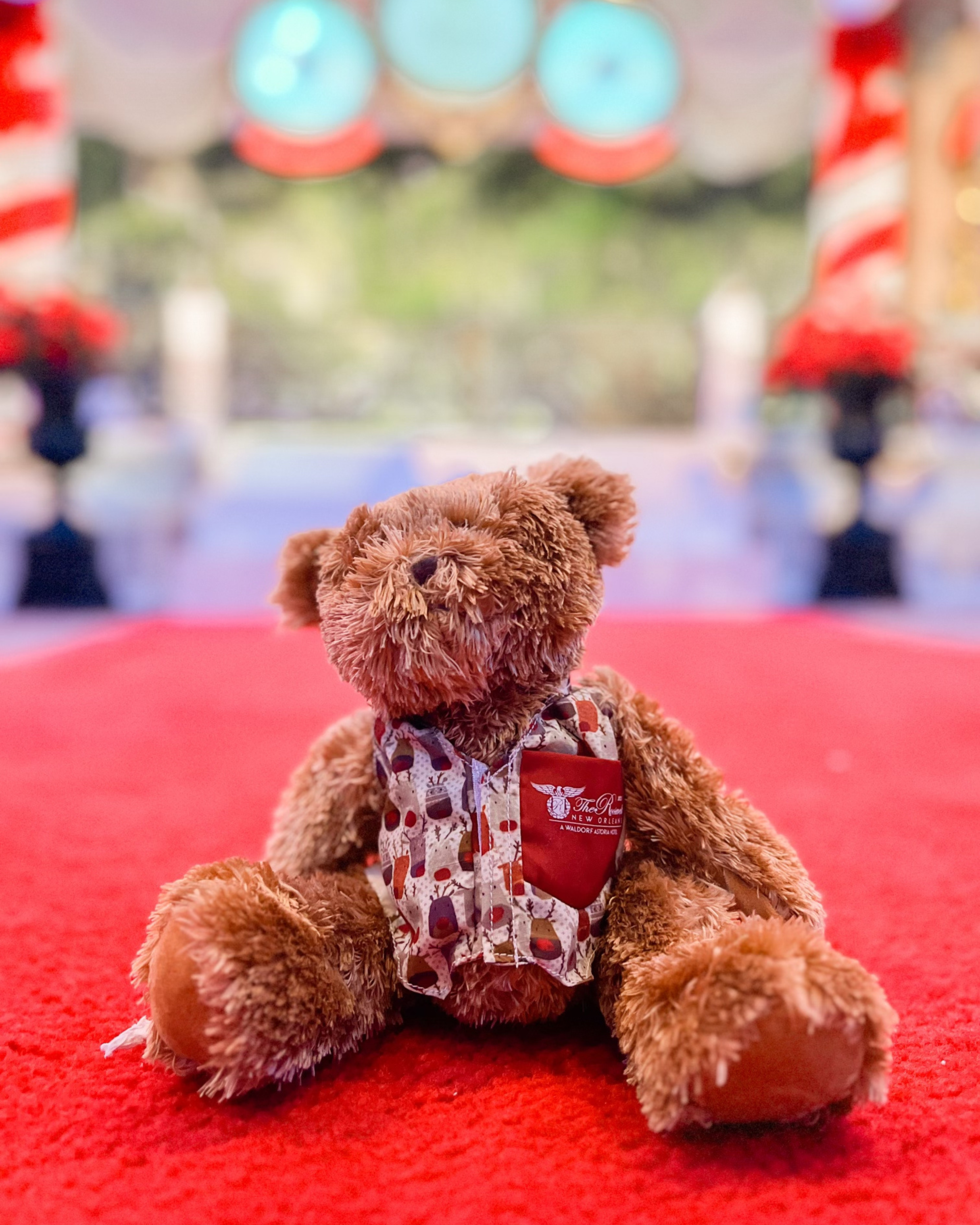 Teddy bear on a red carpet at a holiday teddy bear tea