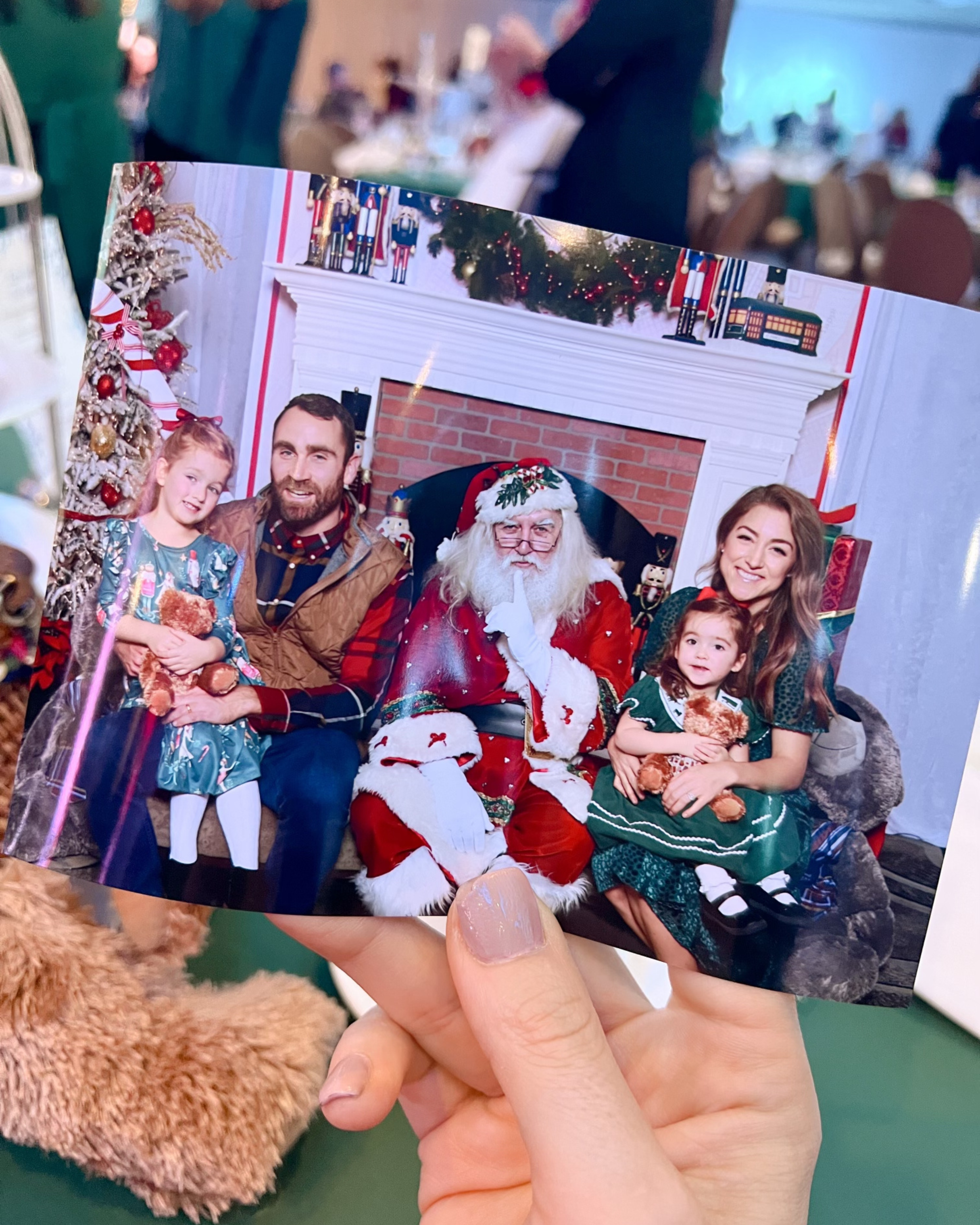 Holding a family photo with Santa from the teddy bear tea