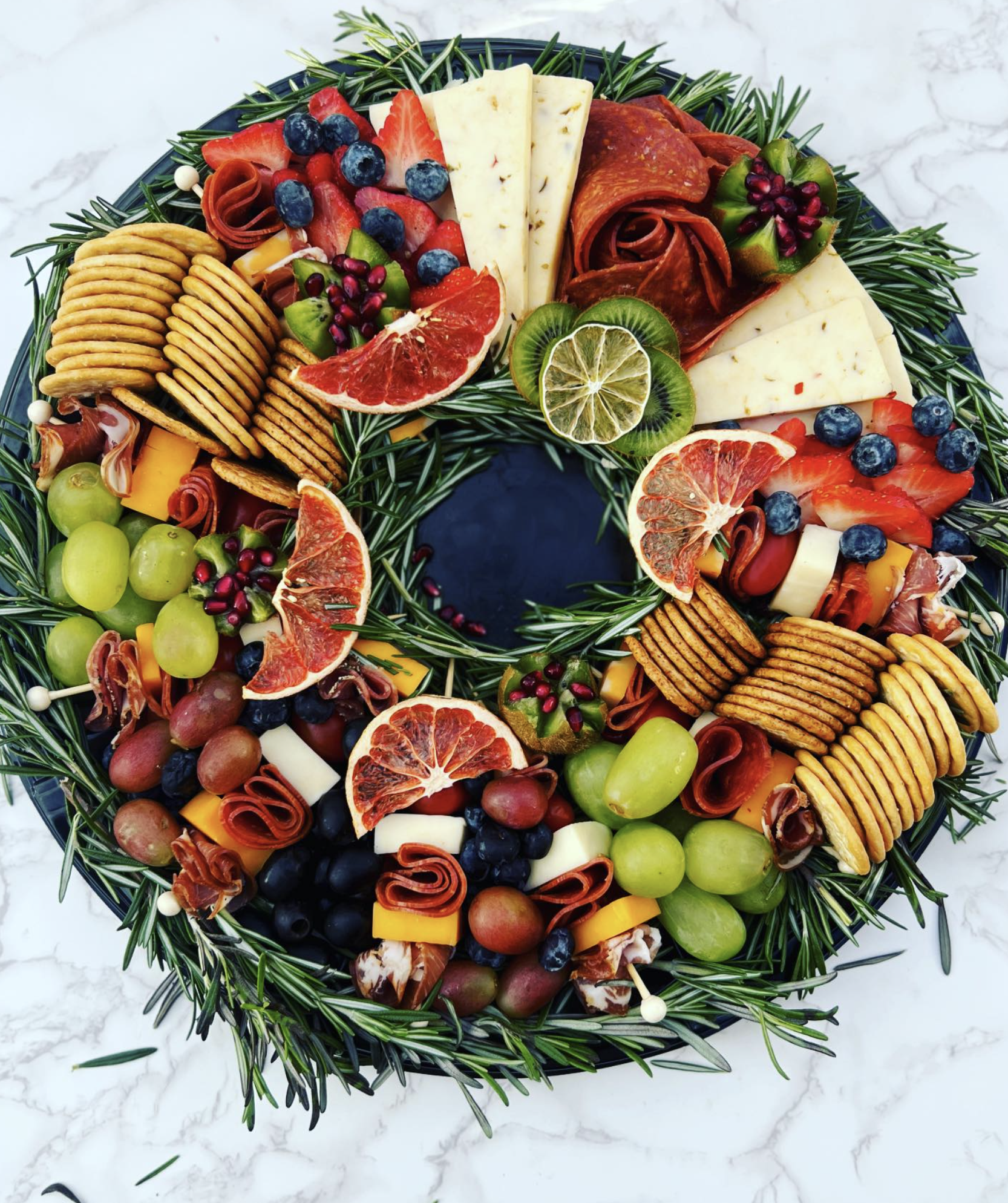 Large charcuterie board with fruit, meats and cheeses