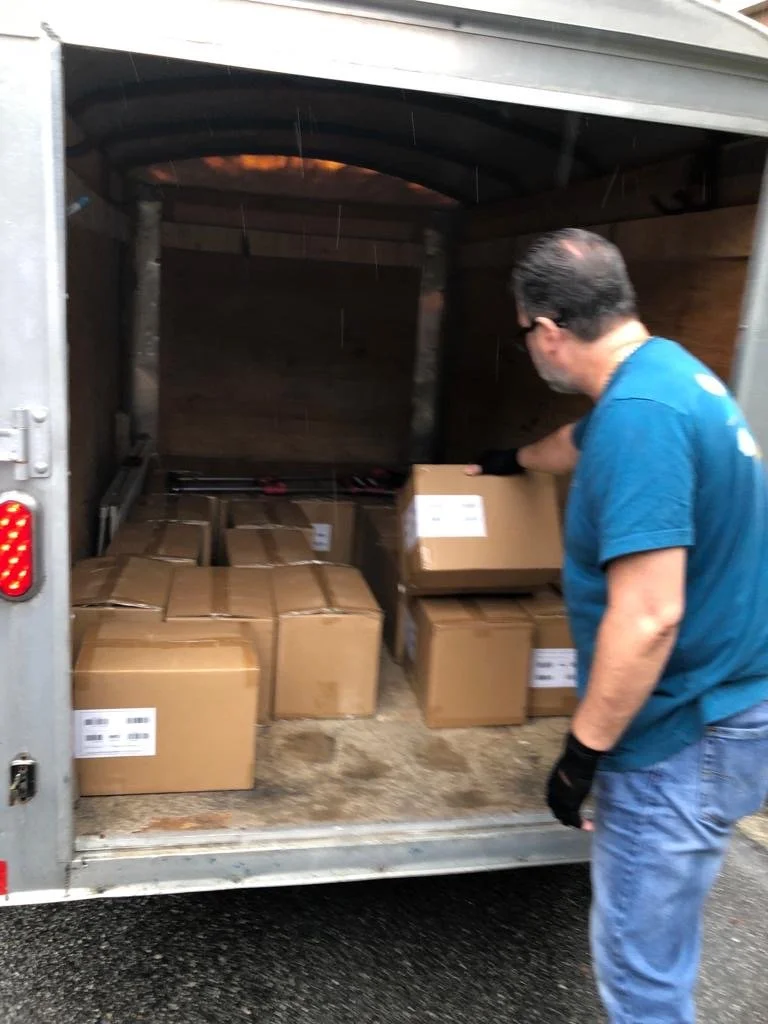 Worker loading cardboard boxes into a delivery truck