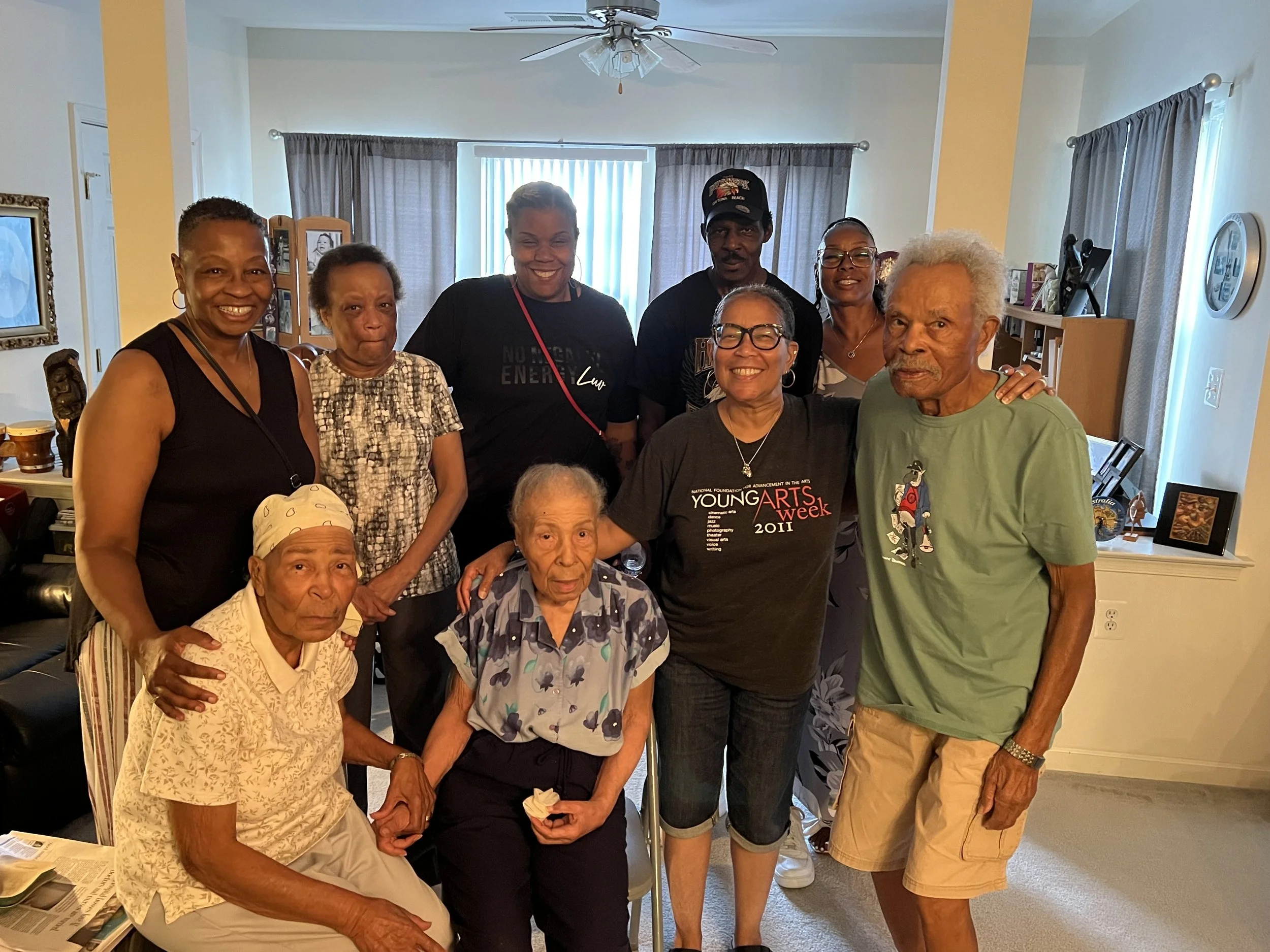 Multigenerational Black family group posing together in a living room.