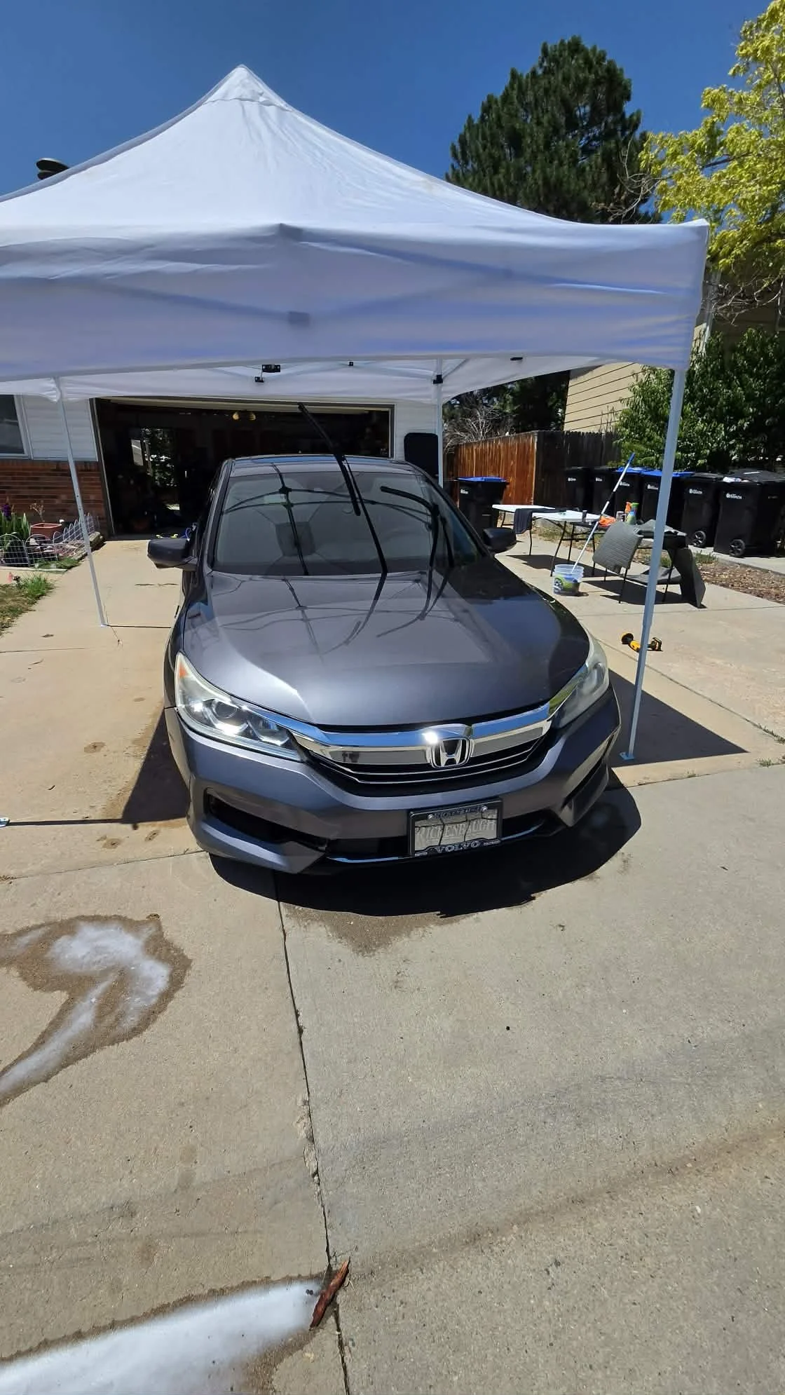 Gray Honda sedan parked beneath a white canopy in a residential driveway