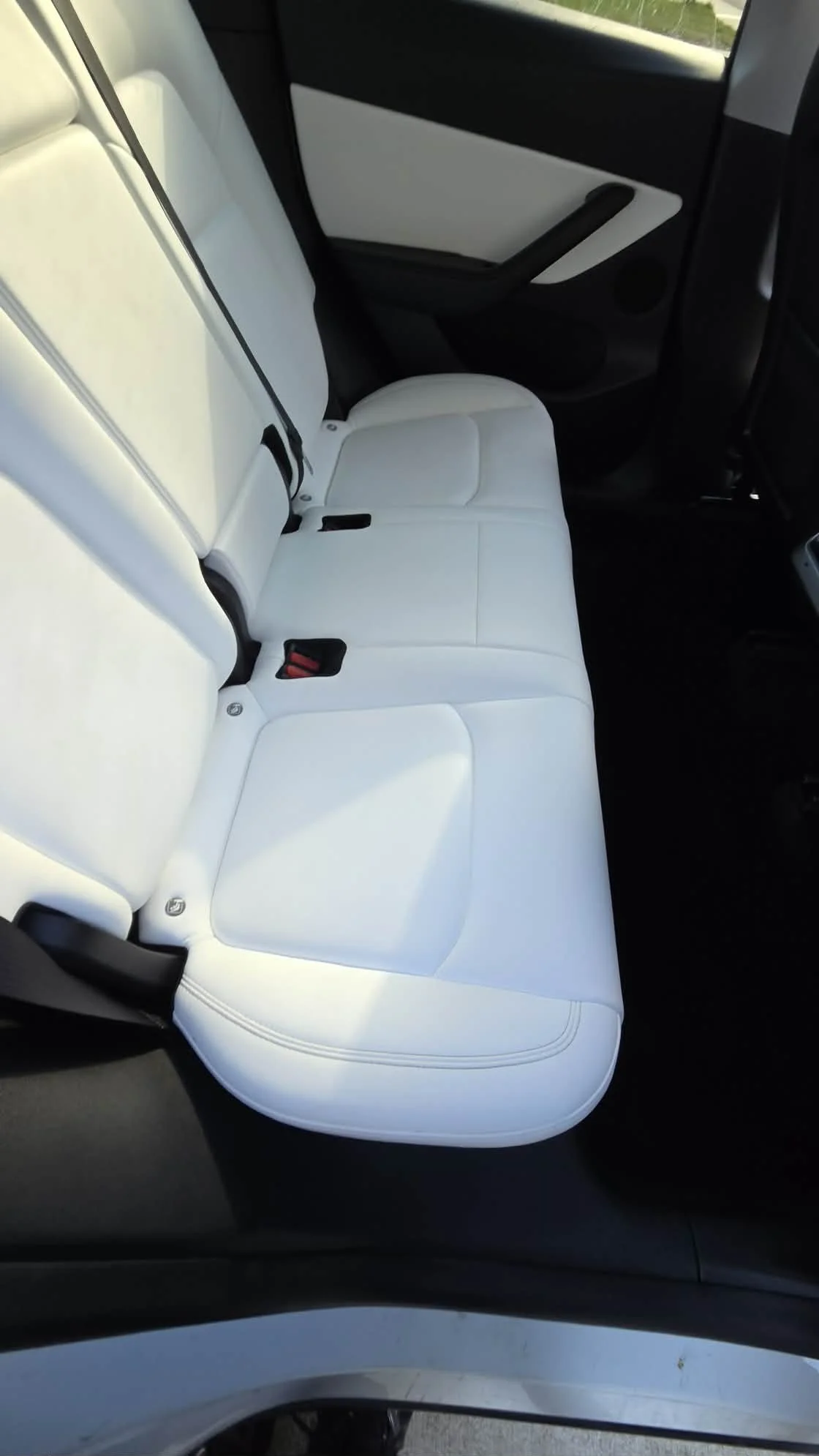 White leather rear seats and black door panel inside a modern car
