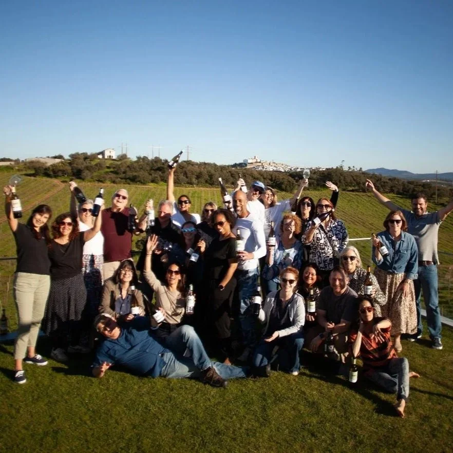 a picture of a group of people cheering with their wine in a field