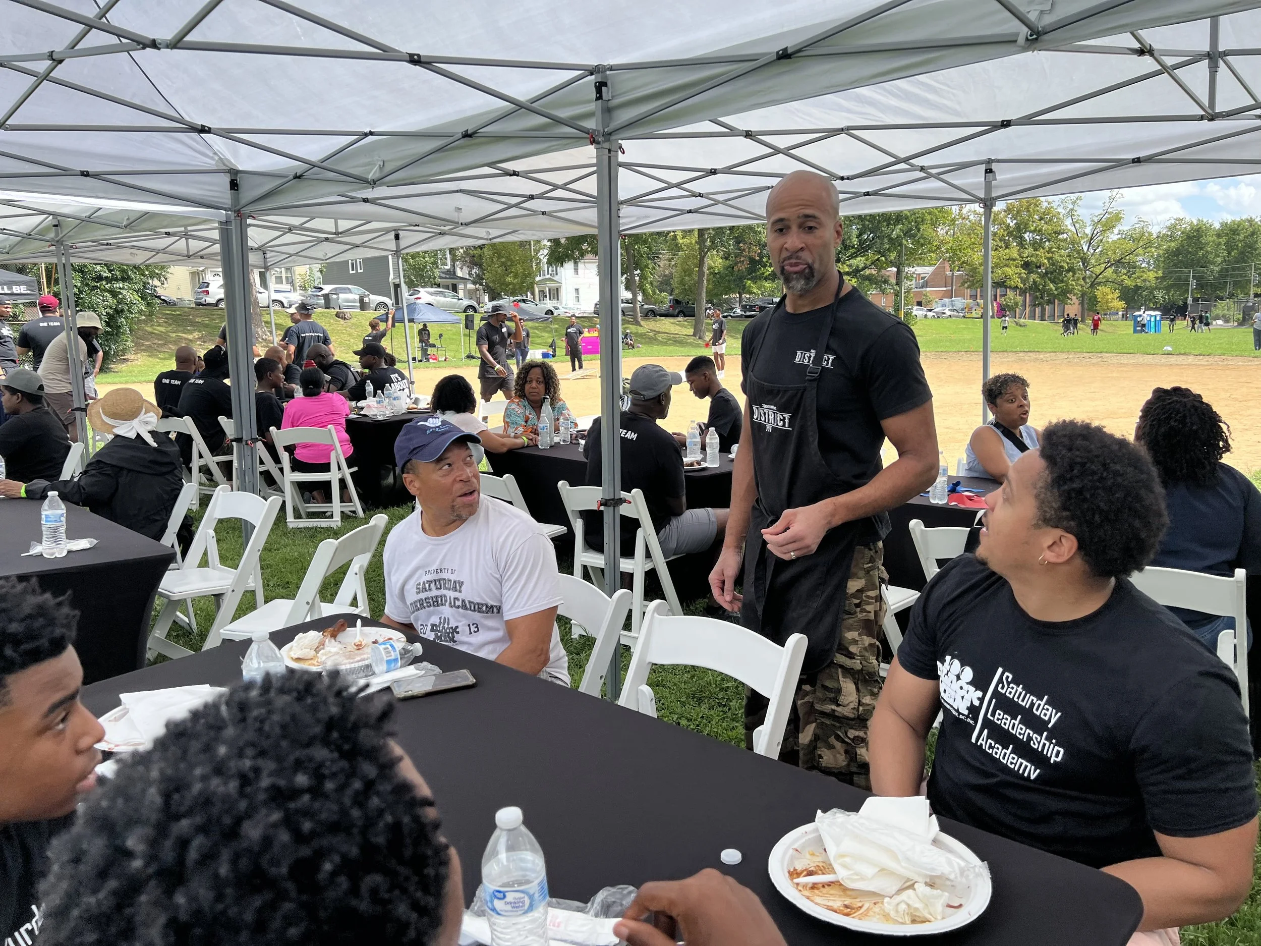 picture of roger talking to customers that are sitting at a table