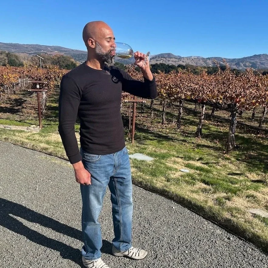 picture of a man wearing jeans drinking wine