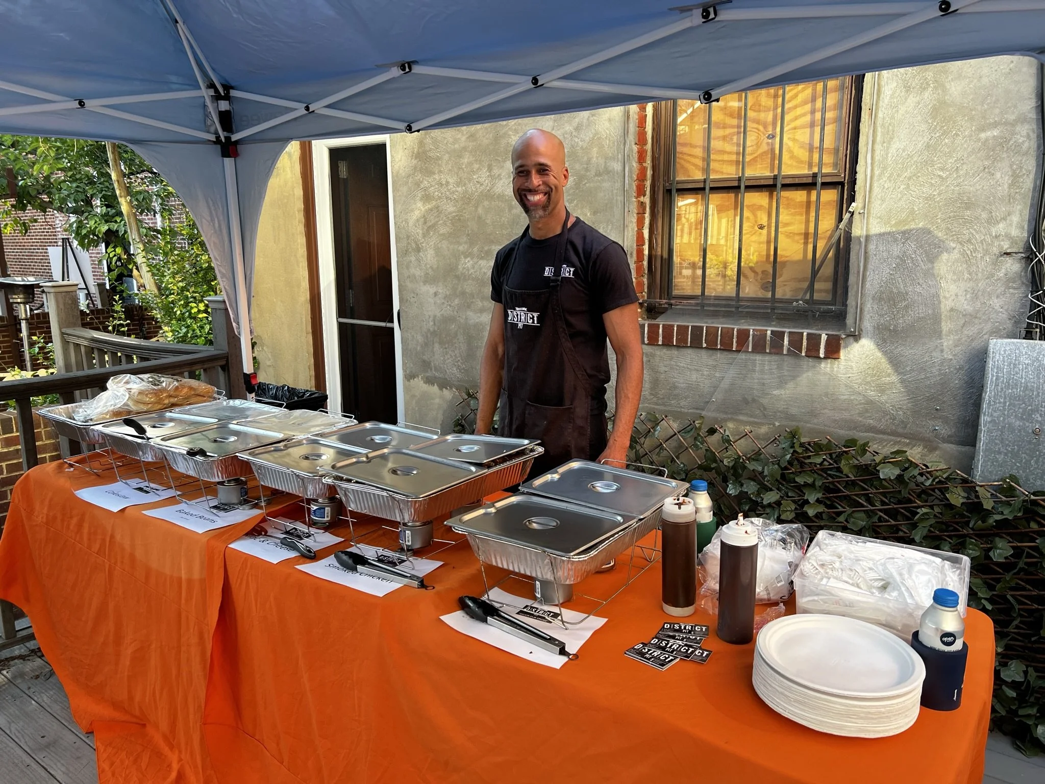 a picture of roger behind a banquet table with food to serve