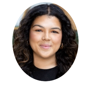 Portrait of a smiling woman with curly dark hair wearing a black top and hoop earrings
