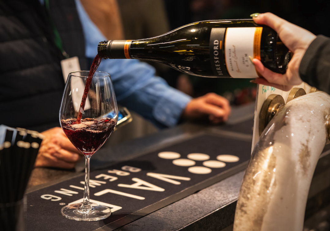Red wine being poured from a bottle into a wine glass at a bar