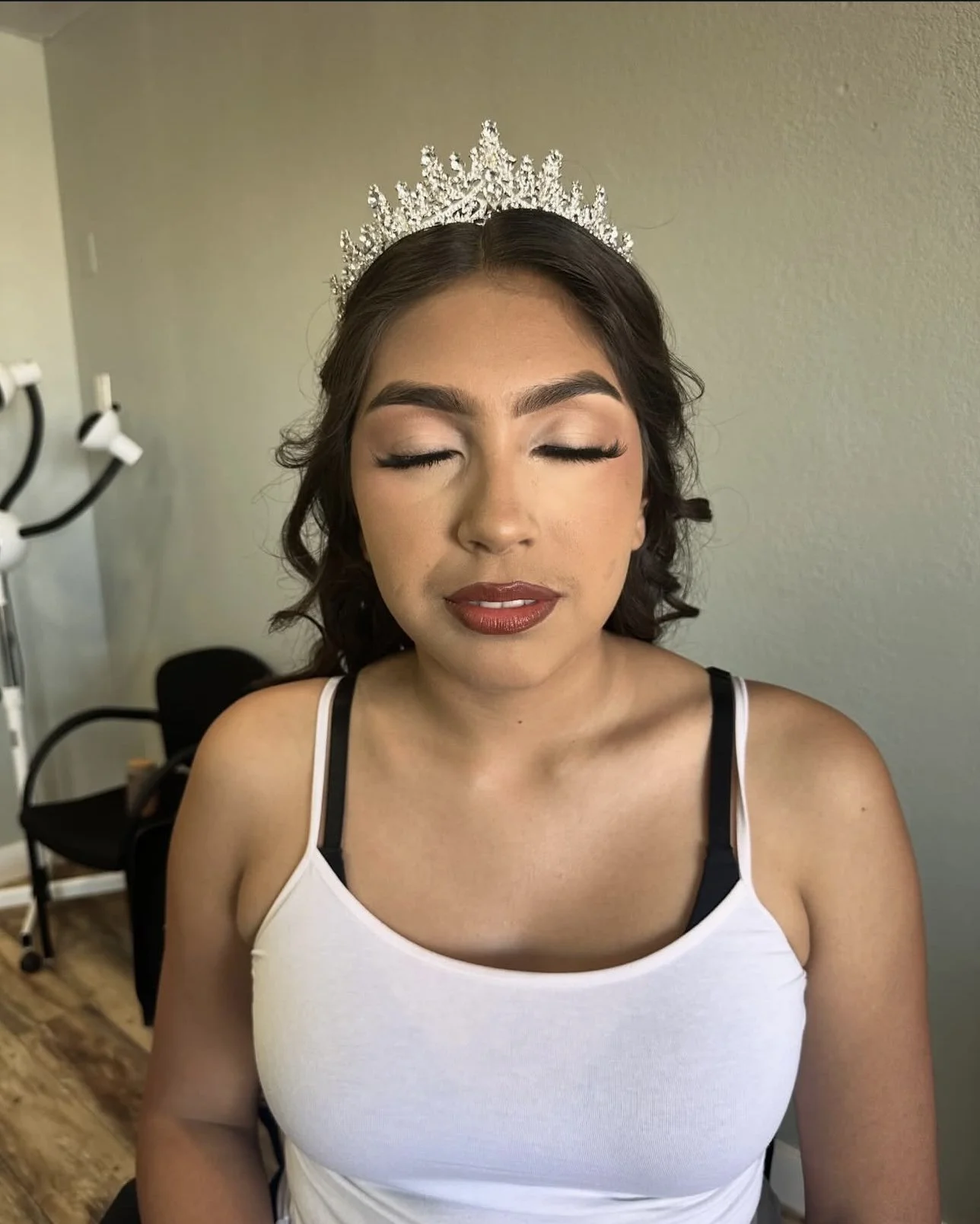 Woman wearing a sparkling silver tiara and white sleeveless top
