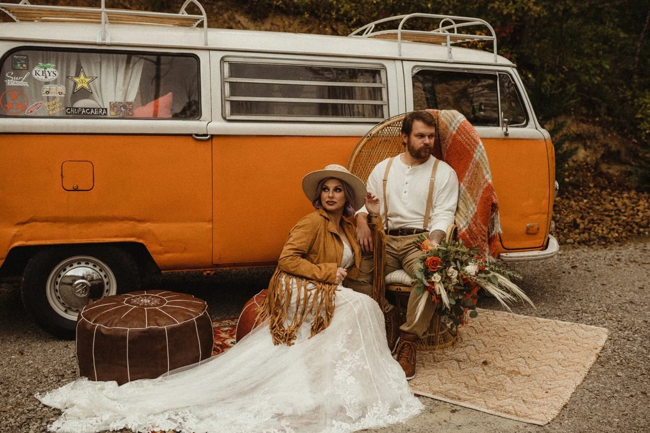 Boho wedding couple seated by Nancy, orange VW bus