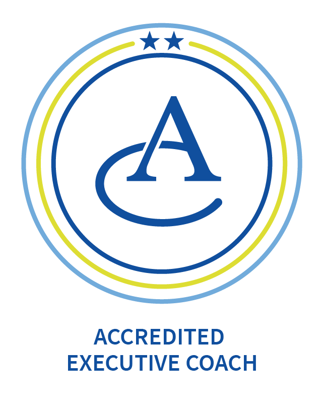 Badge with A logo and two blue stars at the top, encircled by blue and yellow rings. Text below reads "ACCREDITED EXECUTIVE COACH."