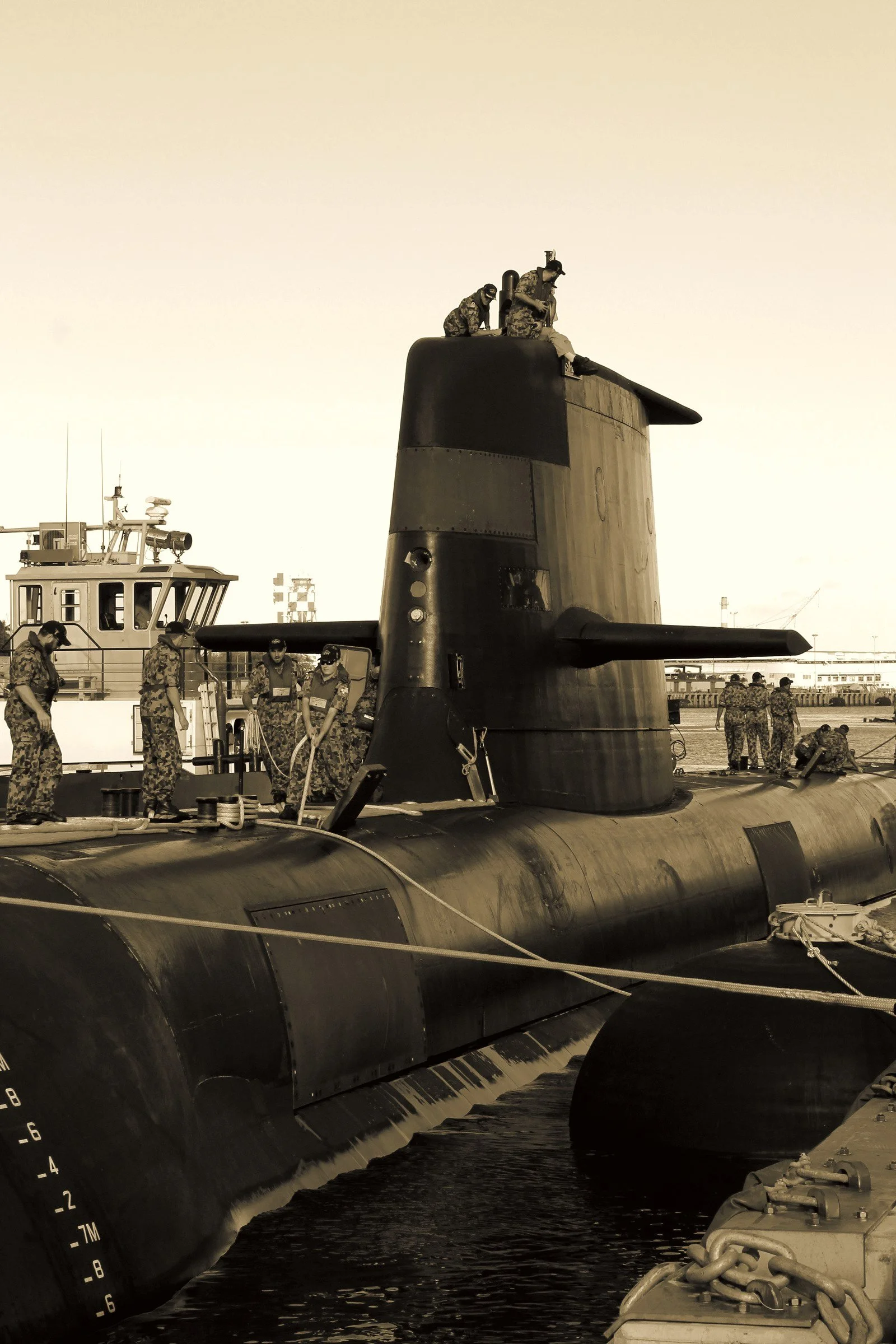 Royal Australian Navy sailors handling mooring lines together on the submarine HMAS Sheean
