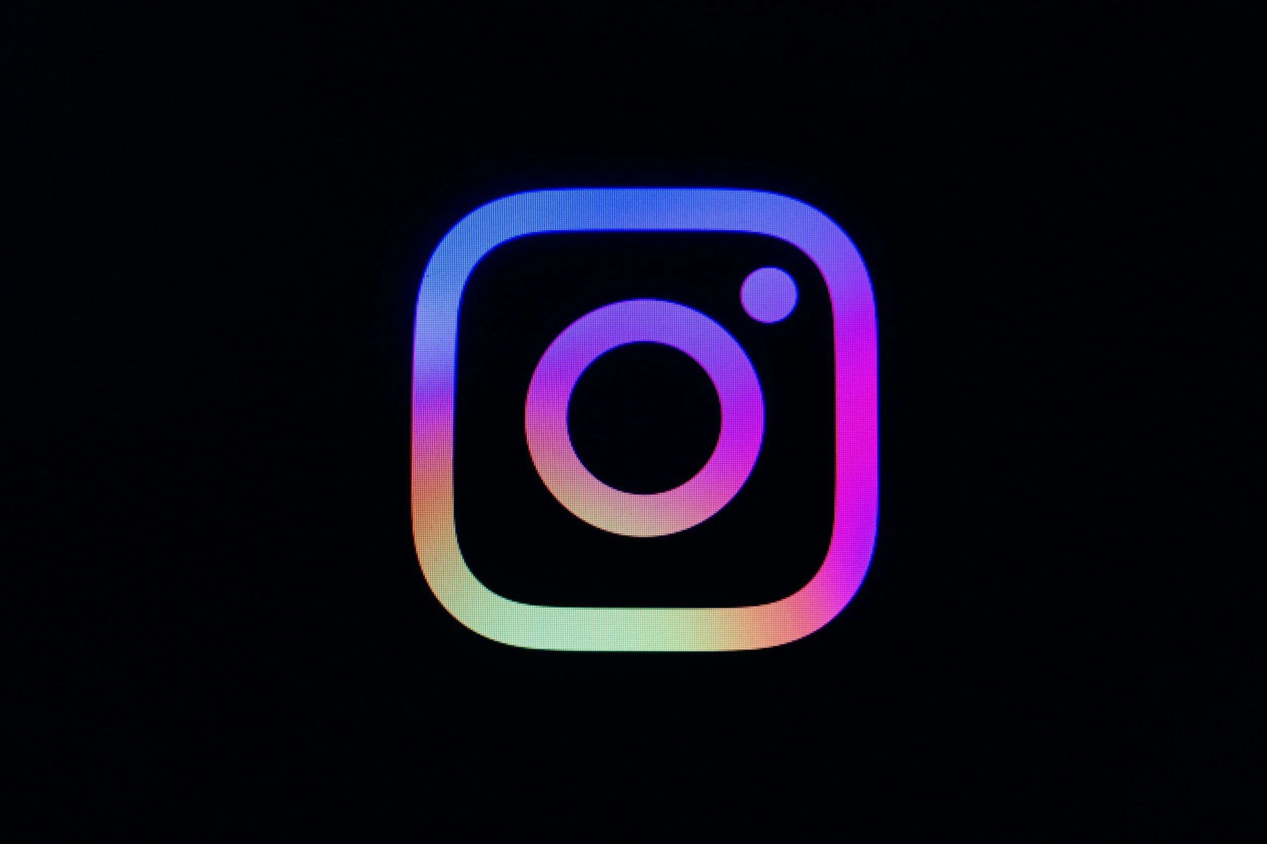 Neon gradient Instagram logo on a black background