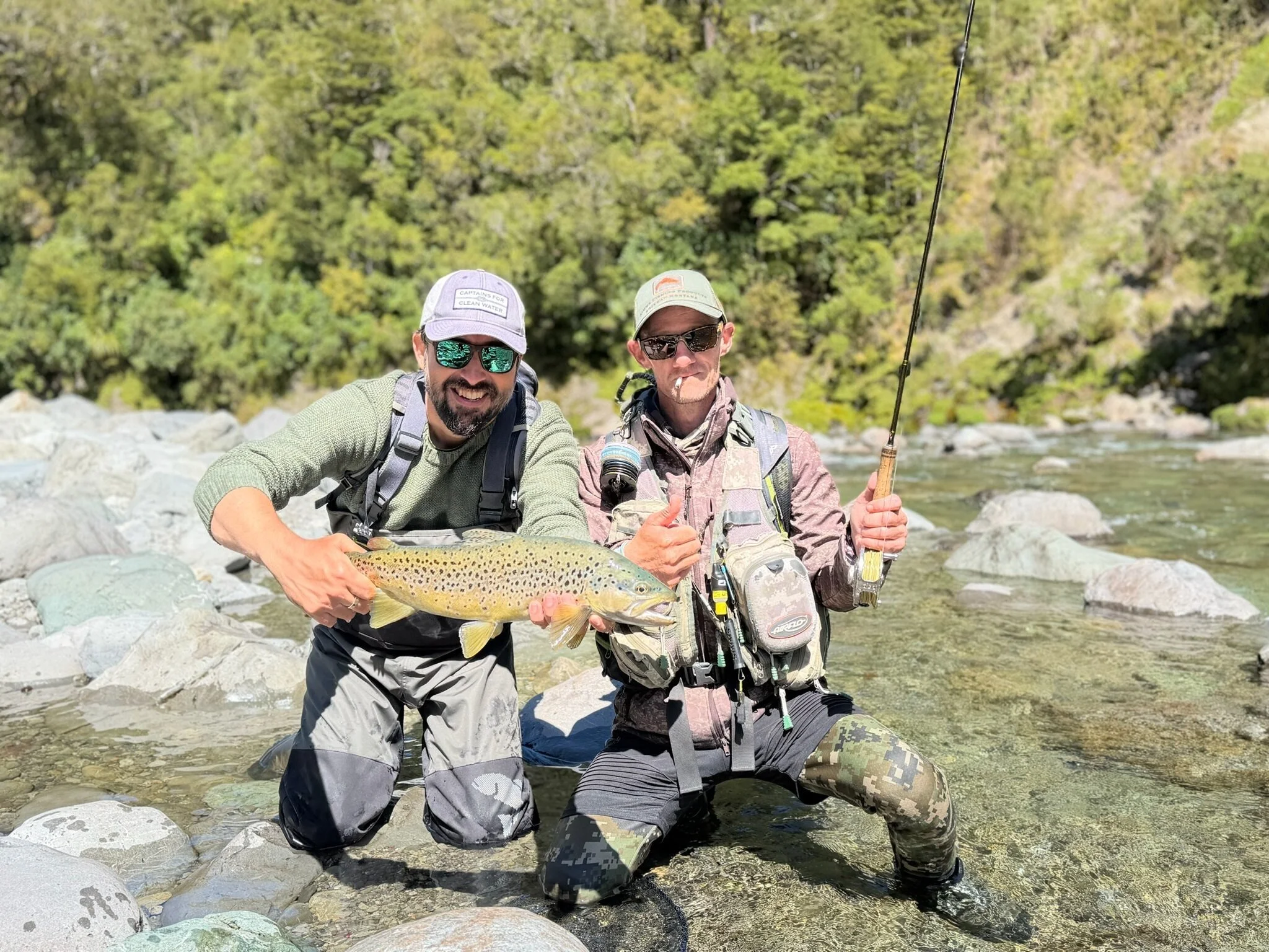 Anglers sharing a catch on the river