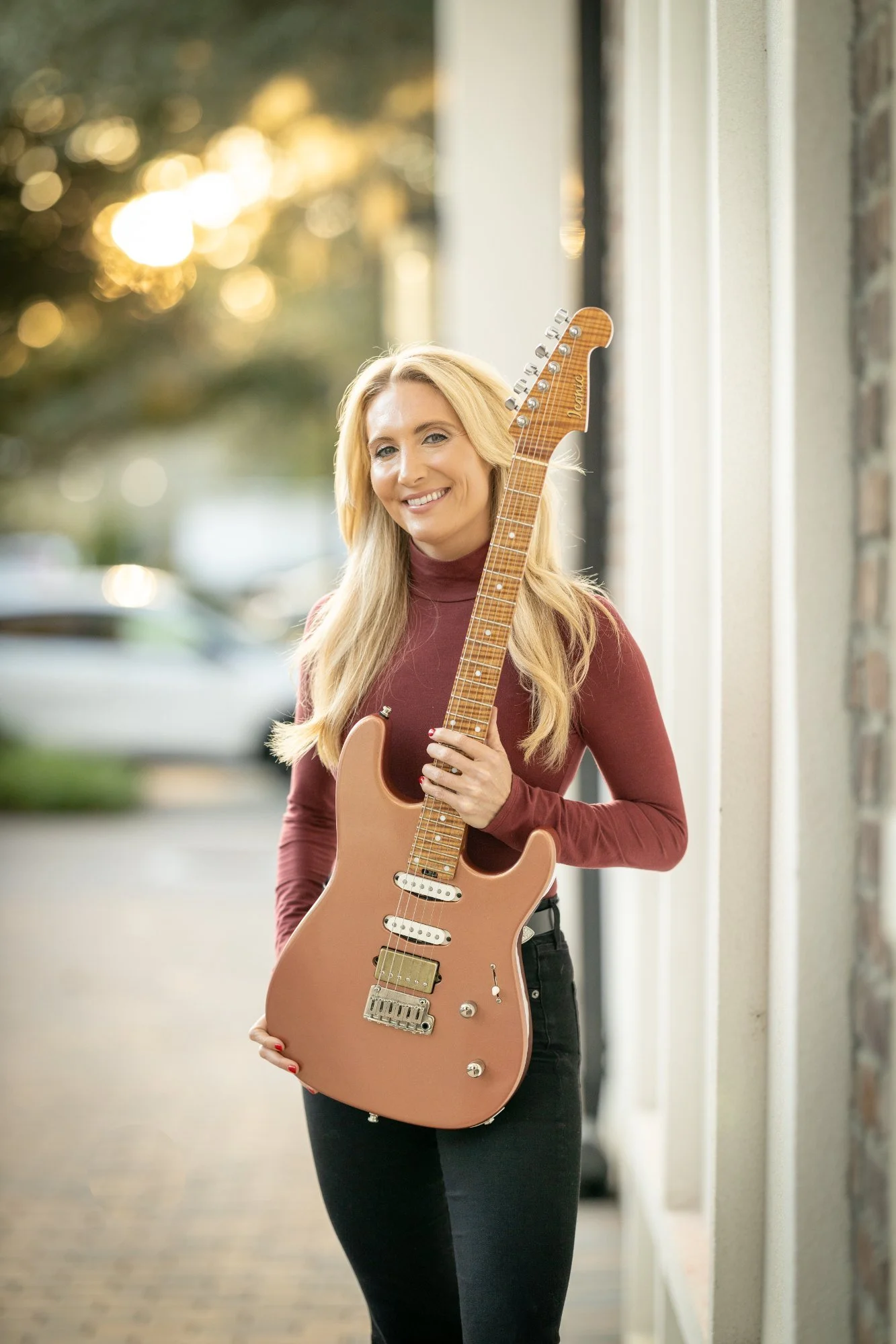 Caitlin Caggiano holding her guitar on Main Street in Windermere