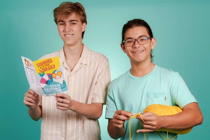 Two teens with books and summer reading prizes at the Orange County Library System