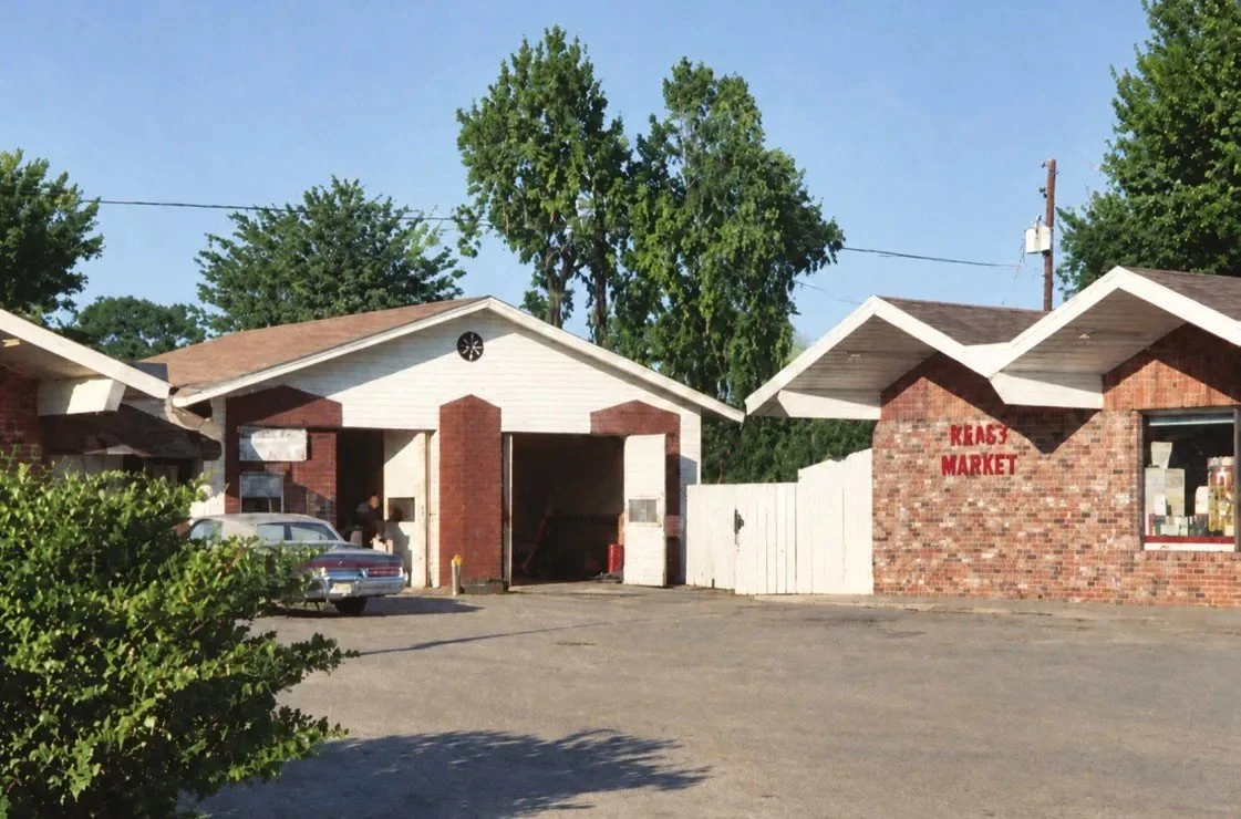 Single-story brick commercial buildings with garage bays and a parking lot