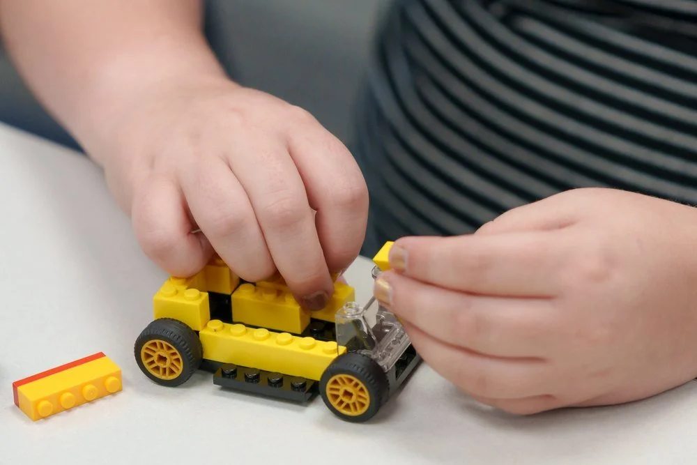 Child building a LEGO car at an Orange County Library System LEGO program