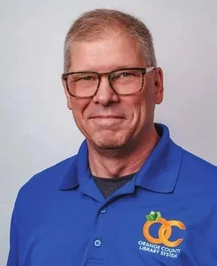 Steve Powell, Library Director/CEO of the Orange County Library System, in a blue Orange County Library System polo shirt