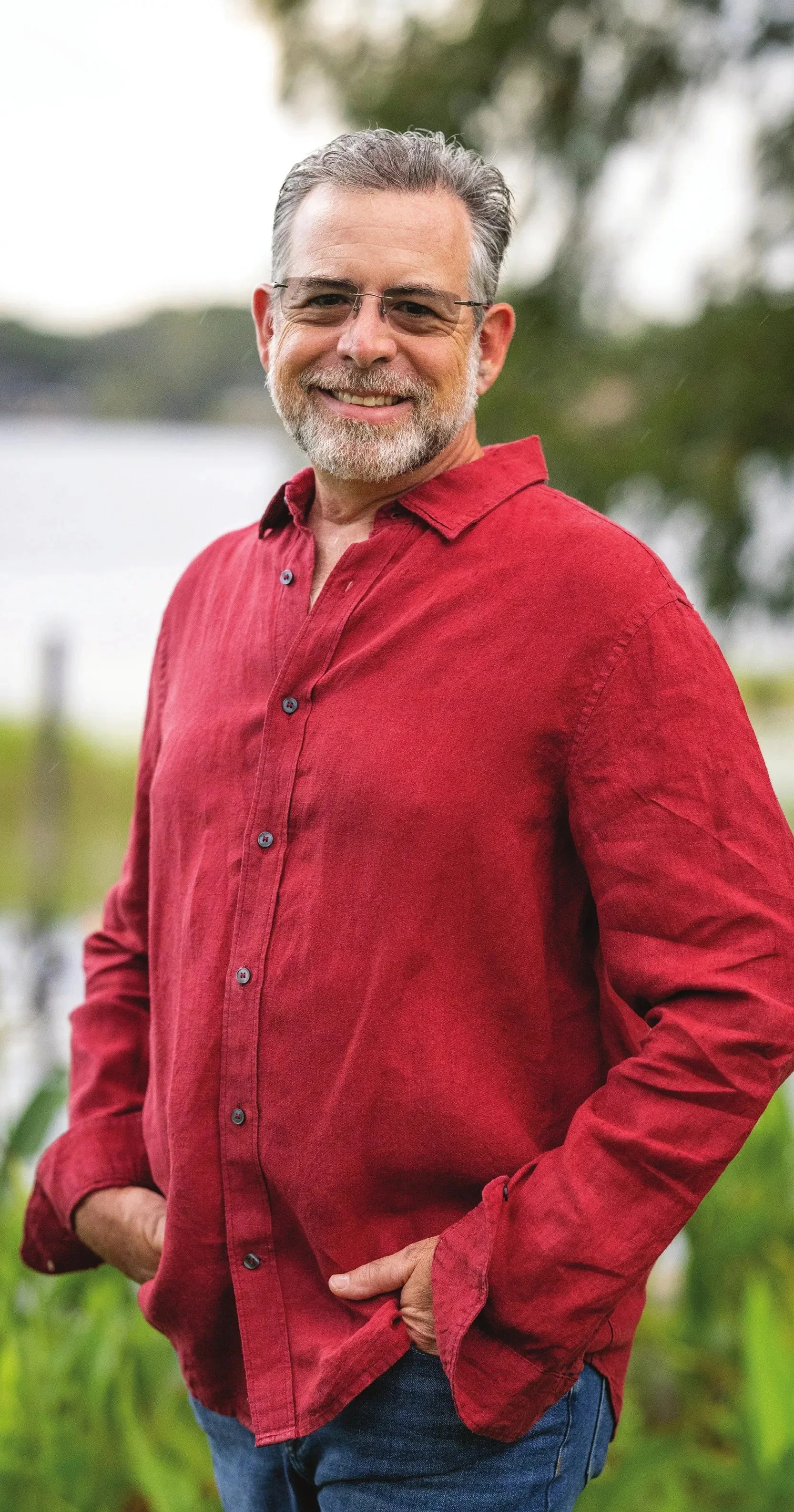 Windermere Mayor Andy Williams in a red button-down shirt and jeans, standing outdoors with his hands in his pockets