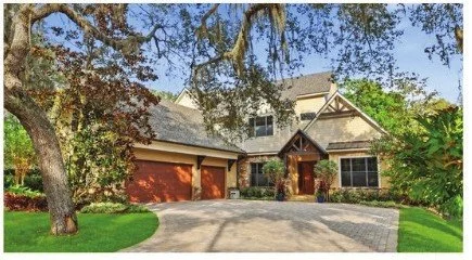 Craftsman-style Windermere home with a stone driveway under a large oak tree