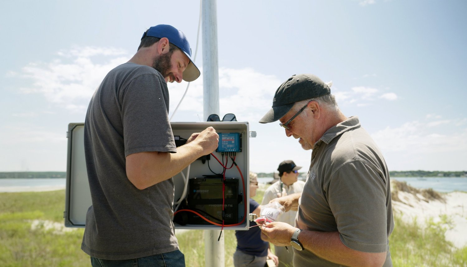 Jon Waddell and Jesse McNinch install the control box for a wave sensor system in Plymouth, Massachusetts