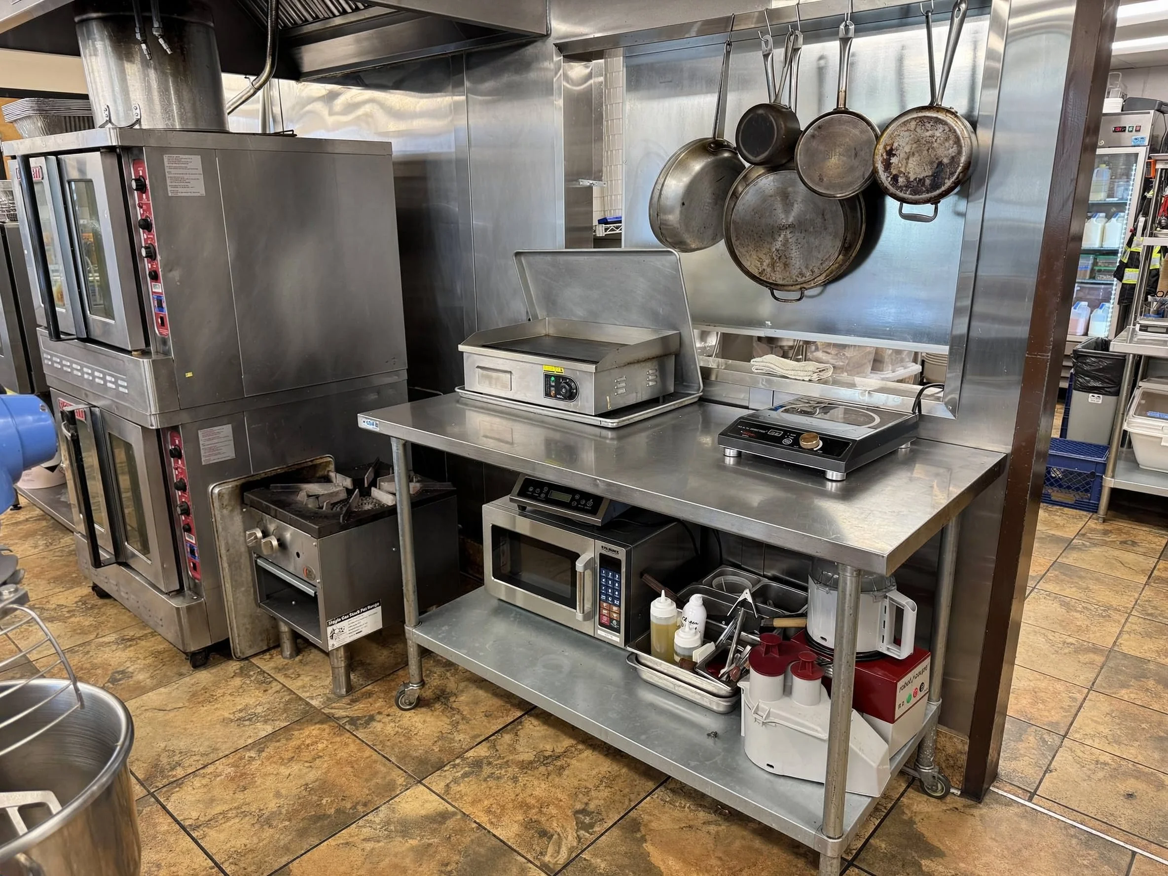 Cook line with convection ovens, griddle, and induction cooktop at Provision Kitchen in Lakewood, CO