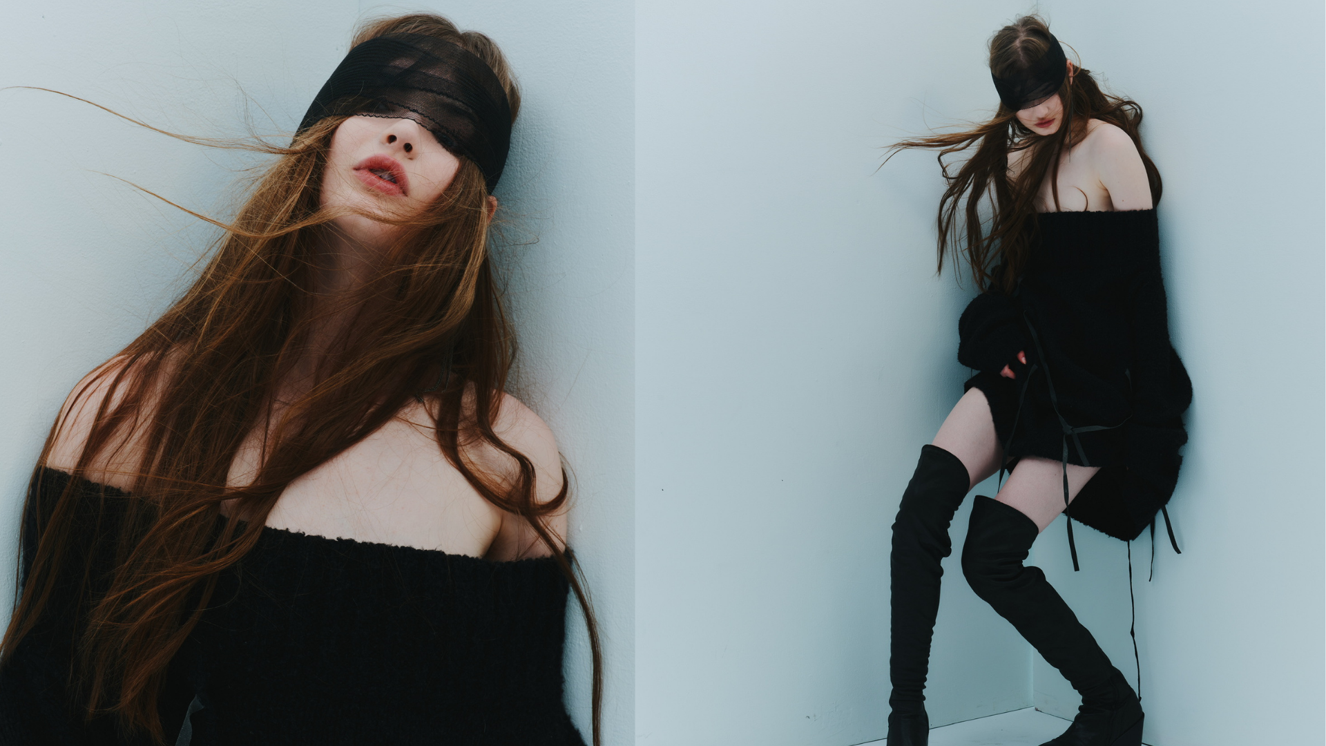 Fashion portrait of a woman with long brown hair wearing a black eye veil, off-the-shoulder outfit, and thigh-high boots against a pale blue wall