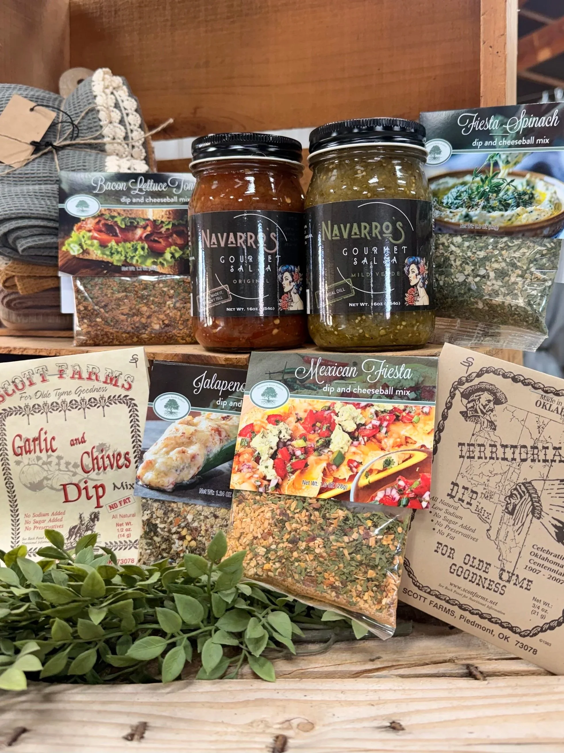 Display of gourmet dip and cheeseball mixes, including bacon lettuce tomato, Fiesta Spinach, jalapeño, garlic and chives, and Mexican Fiesta flavors, with jars of Navarro's gourmet salsa.