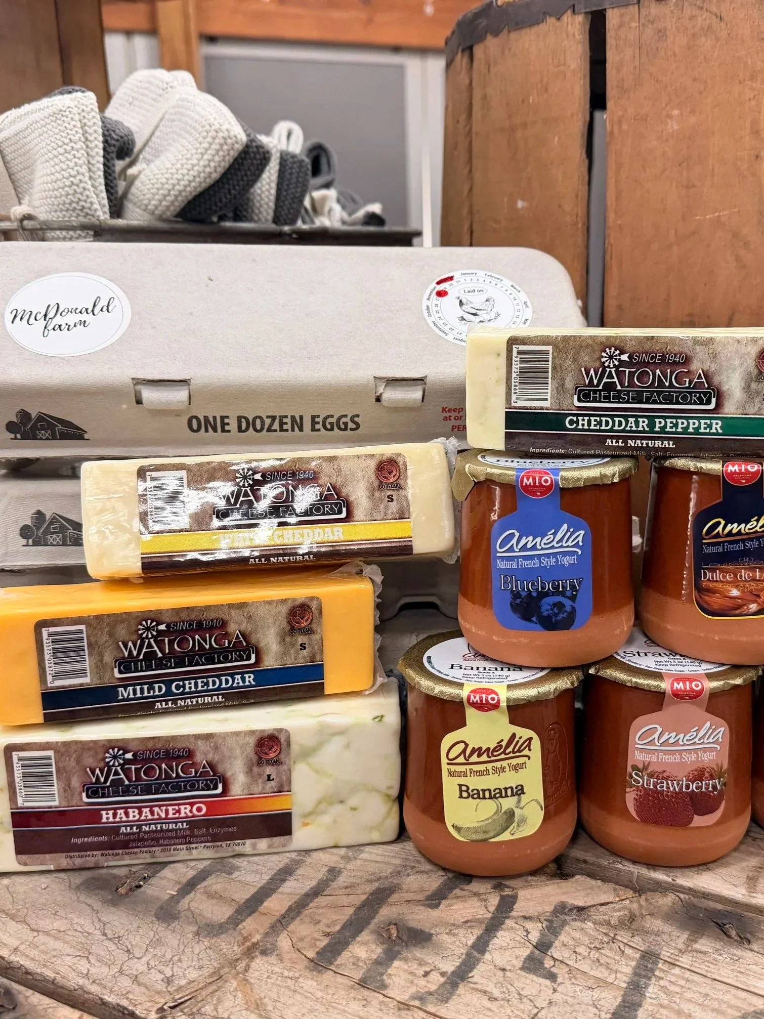 Farm-fresh products including a dozen eggs, W atonga Cheese Factory cheddar and habanero cheeses, and Amelia blueberry, banana, strawberry, and dulce de leche yogurts.
