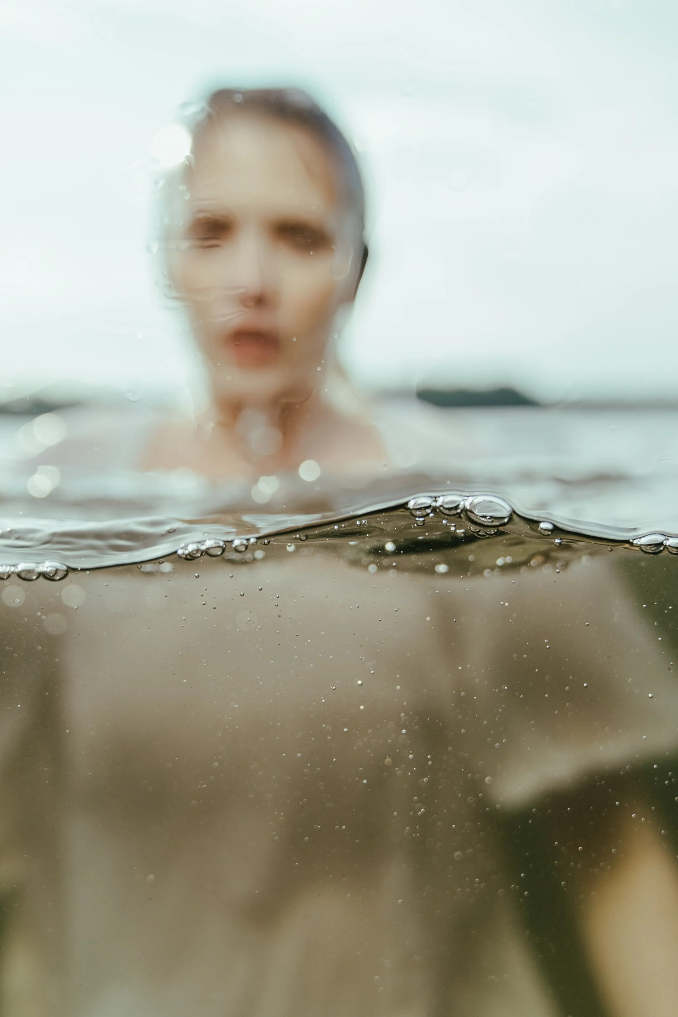 Abstract close-up of muted olive-green textures and soft reflections with a cinematic, editorial feel.