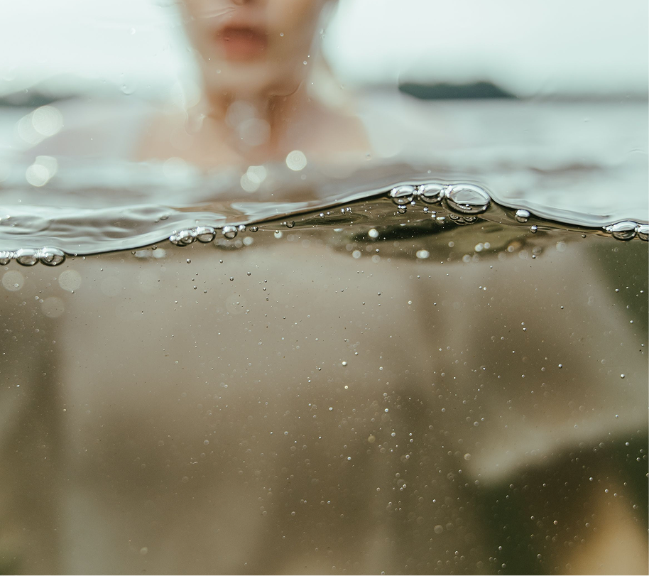 closeup of underwater lake showing the top of a girls neck and blurred background