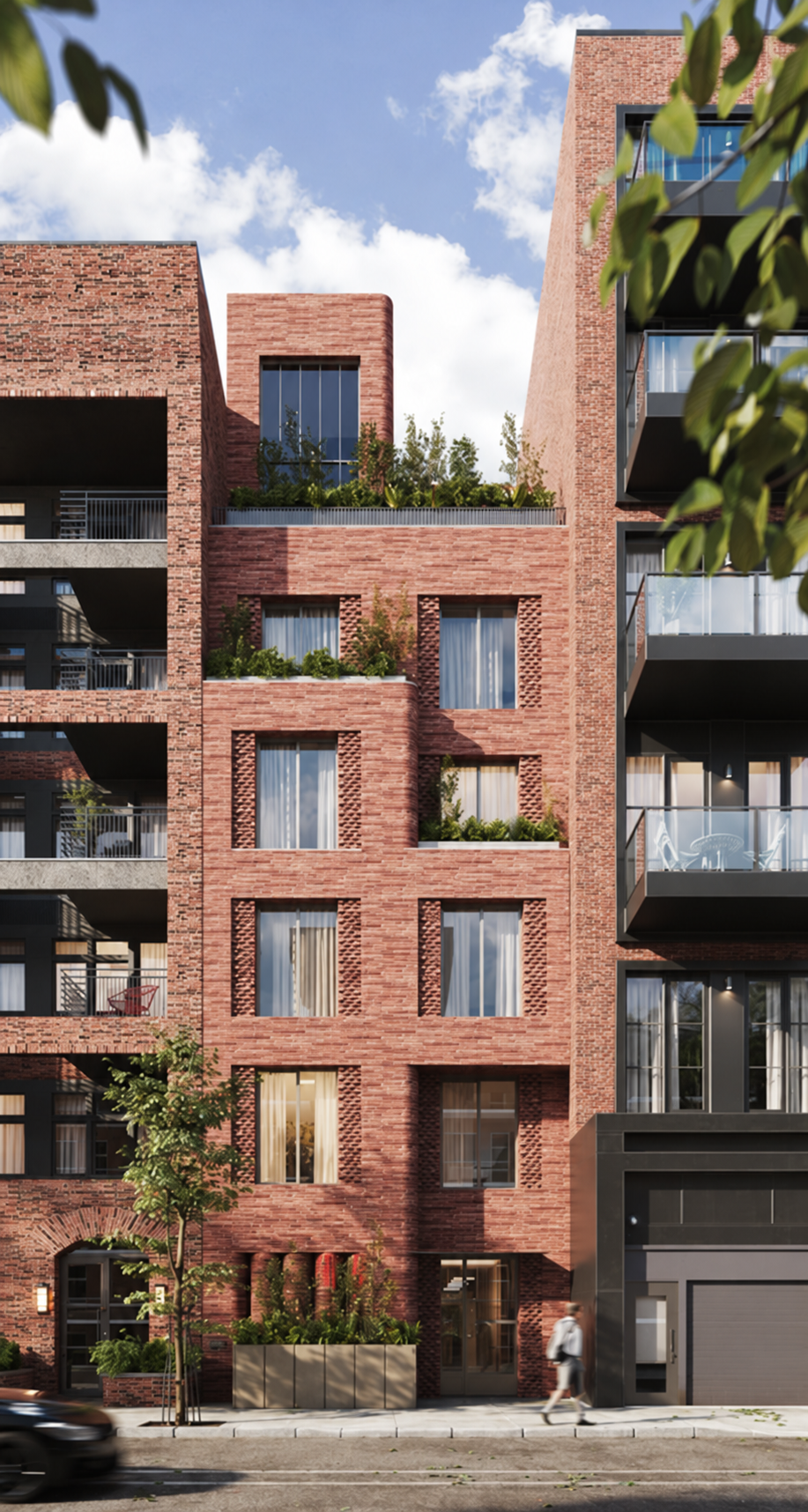 Modern red-brick apartment building with balconies, large windows, rooftop greenery, and street-level landscaping under a blue sky
