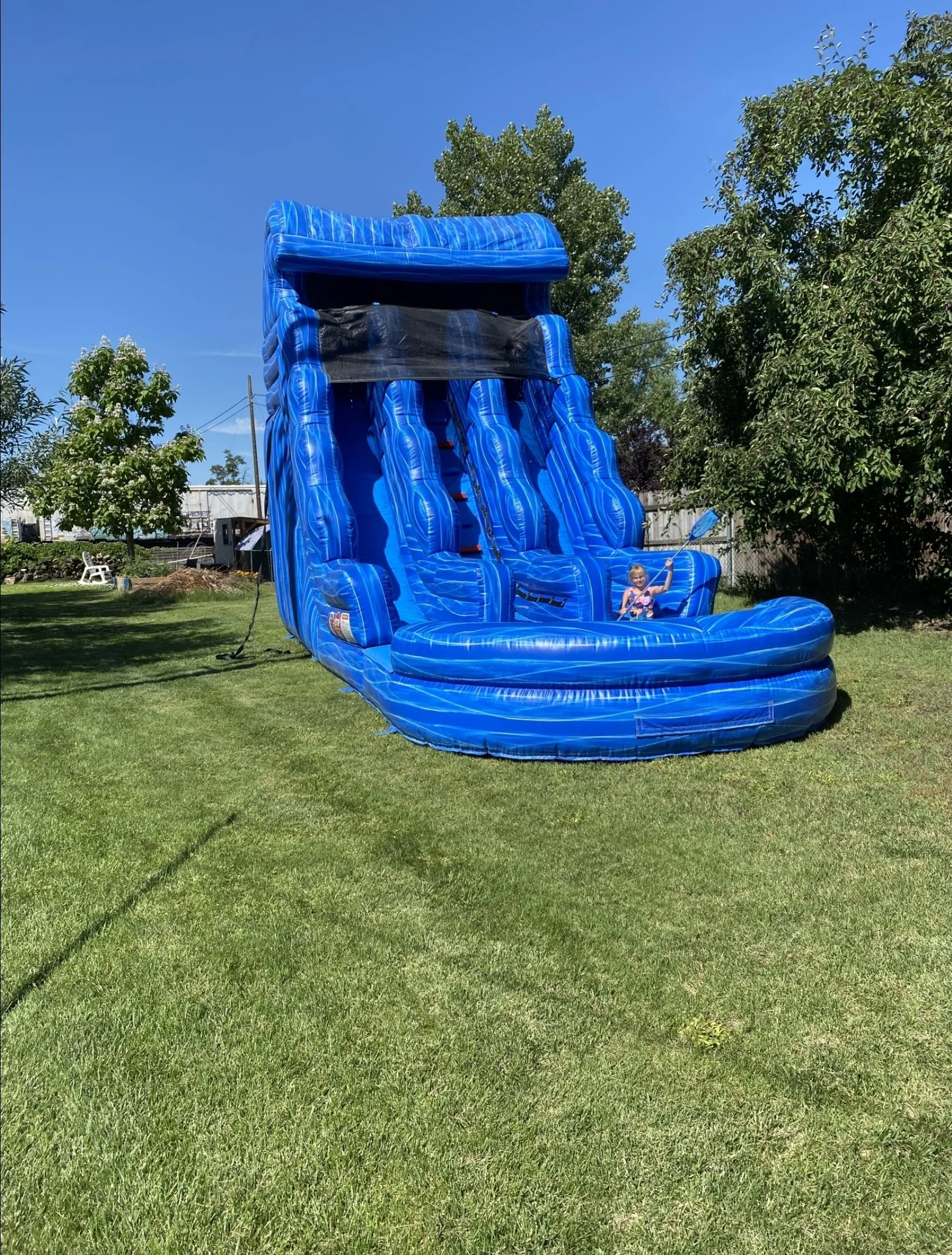Double Trouble 30-foot-tall blue inflatable waterslide with two racing lanes and a large splash pool, set up on a grassy lawn for a backyard rental in the Tri-Cities, WA.