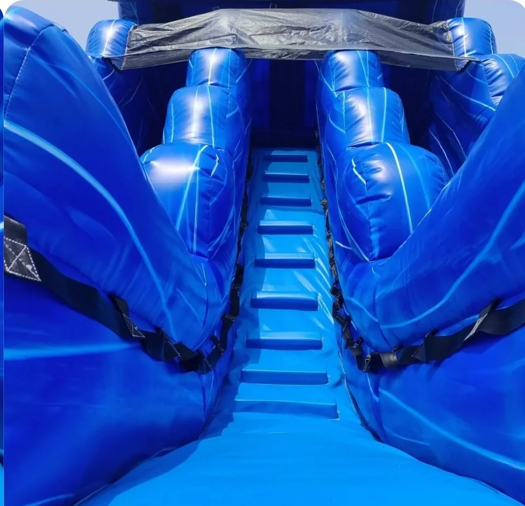 Close-up looking up the Double Trouble inflatable waterslide's blue center climbing lane, showing its tall padded walls and climbing surface.