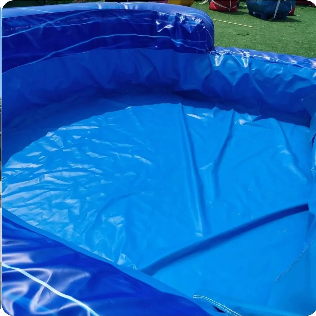 Close-up of Double Trouble's large blue inflatable splash pool, showing the landing area at the bottom of the dual-lane waterslide.
