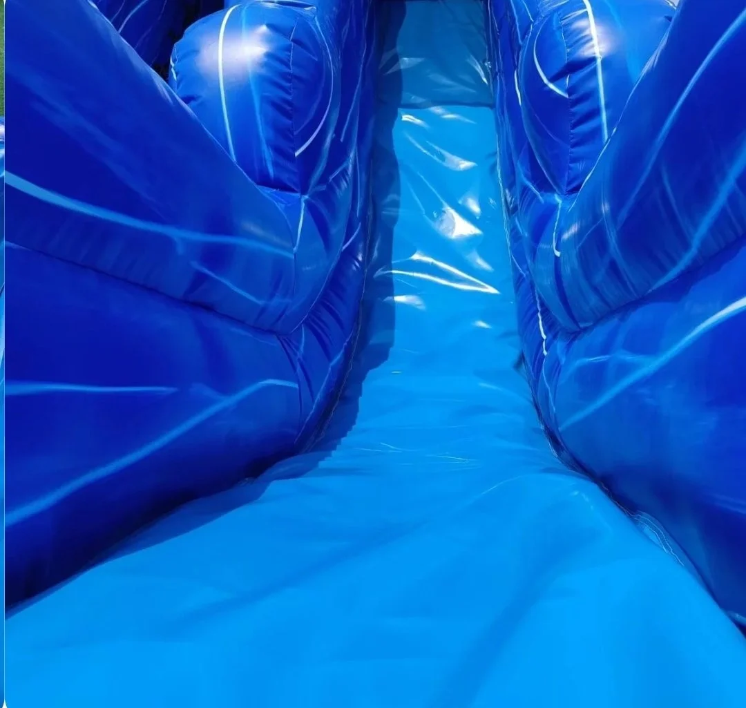 Close-up looking up the Double Trouble inflatable waterslide's blue center climbing lane, showing its tall padded walls and climbing surface.