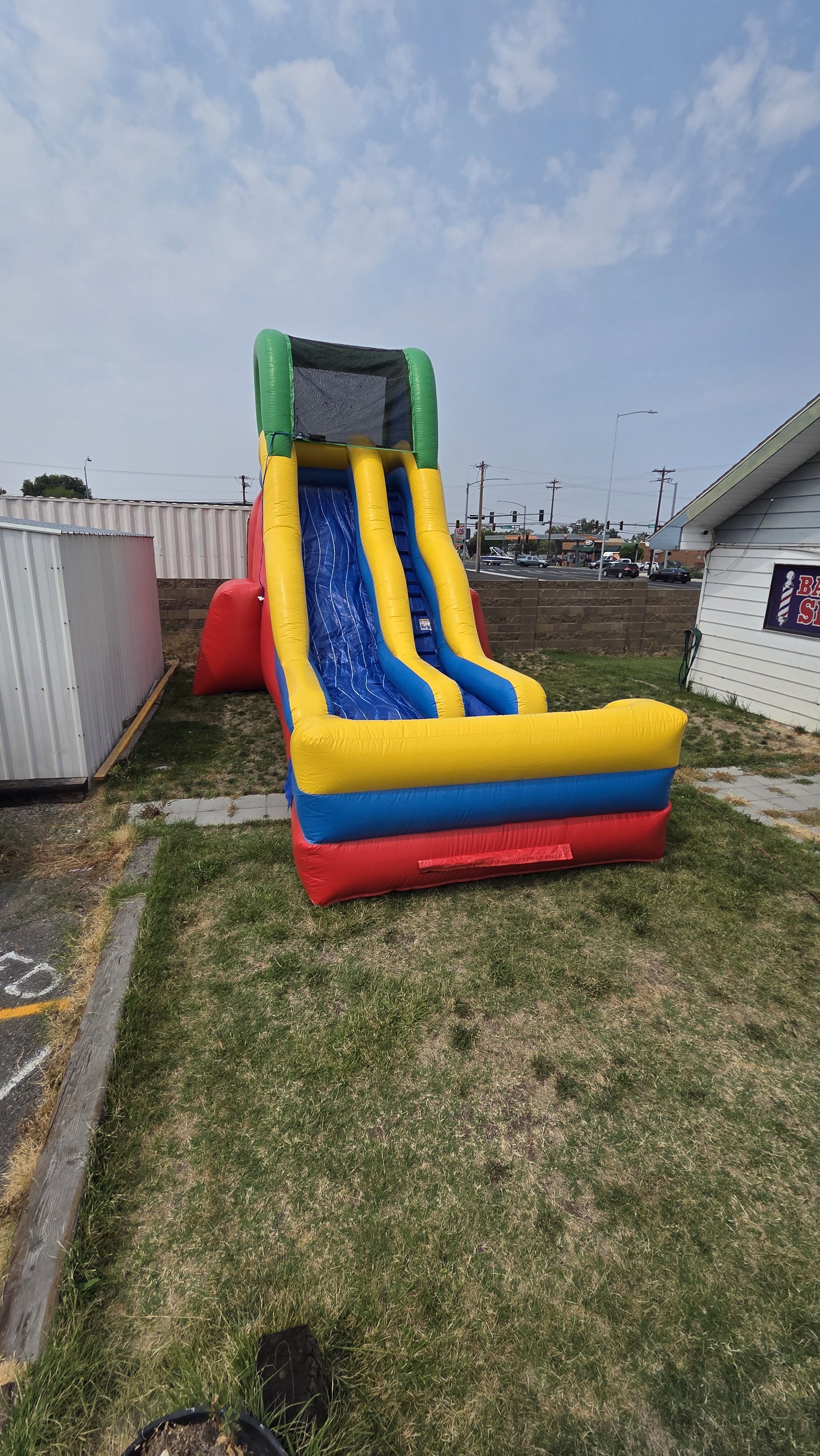 Close-up front view of the Flip Flop inflatable waterslide showing its blue and yellow sliding lanes and colorful inflatable structure.