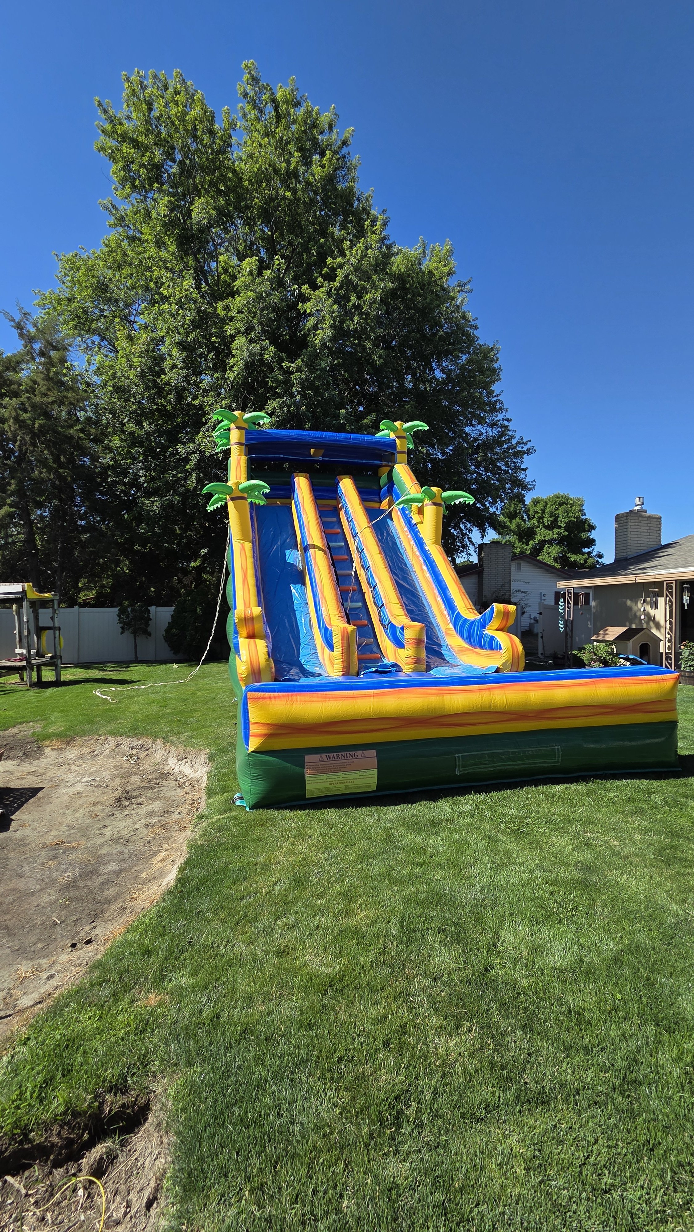 Pompeii 30-foot-tall inflatable waterslide set up in a sunny backyard, available for outdoor parties and events in Richland and the Tri-Cities, WA.