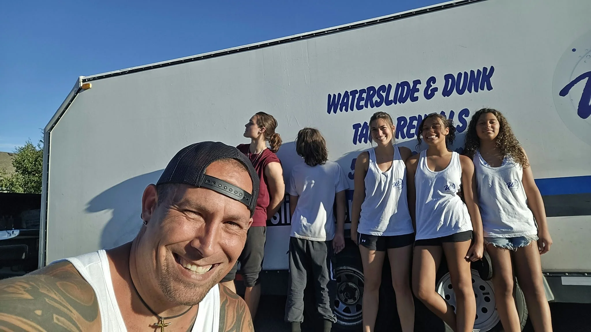 WaterSlides Kennewick team standing in front of their waterslide rental delivery trailer in Kennewick, Washington, serving Richland, Pasco and the Tri-Cities.