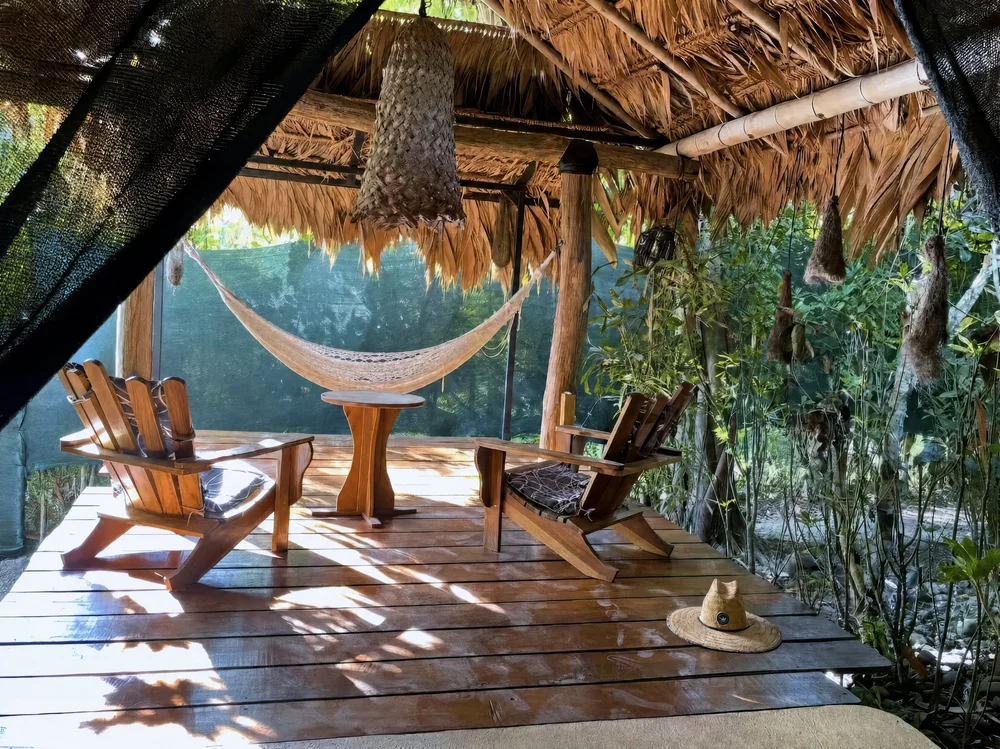 Thatched-roof deck with a hammock and lounge chairs at Casa Del Soul