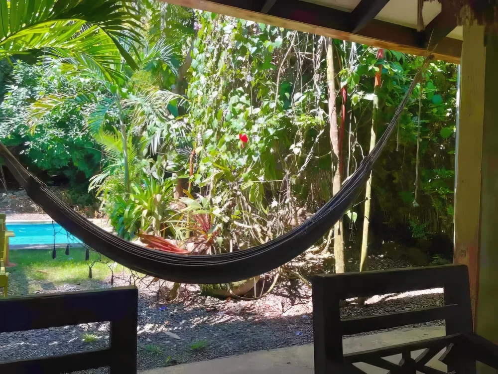 Hammock on a covered patio looking out to the tropical garden