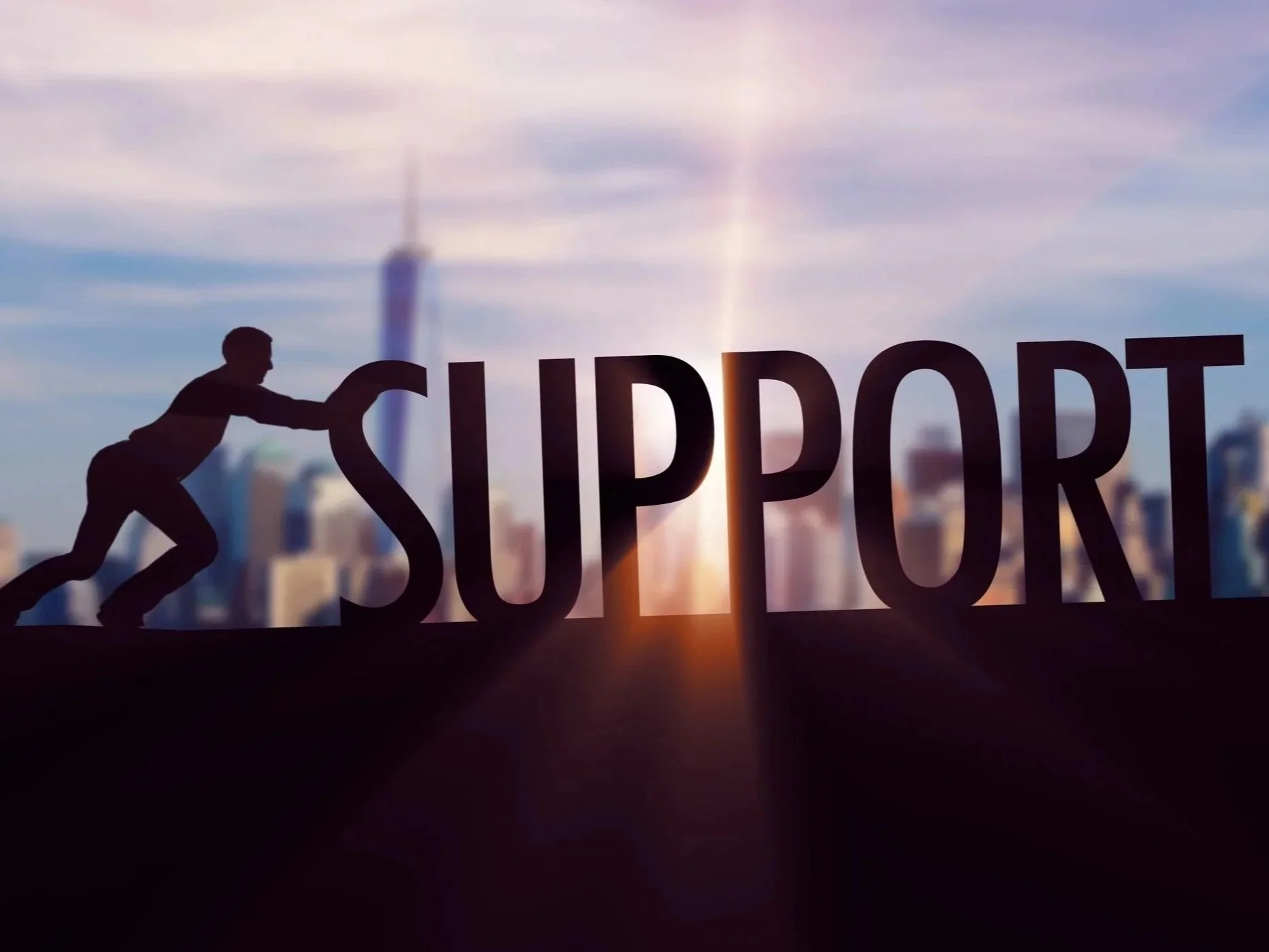 Silhouette of a person pushing the word 'SUPPORT' across a city skyline at sunset.
