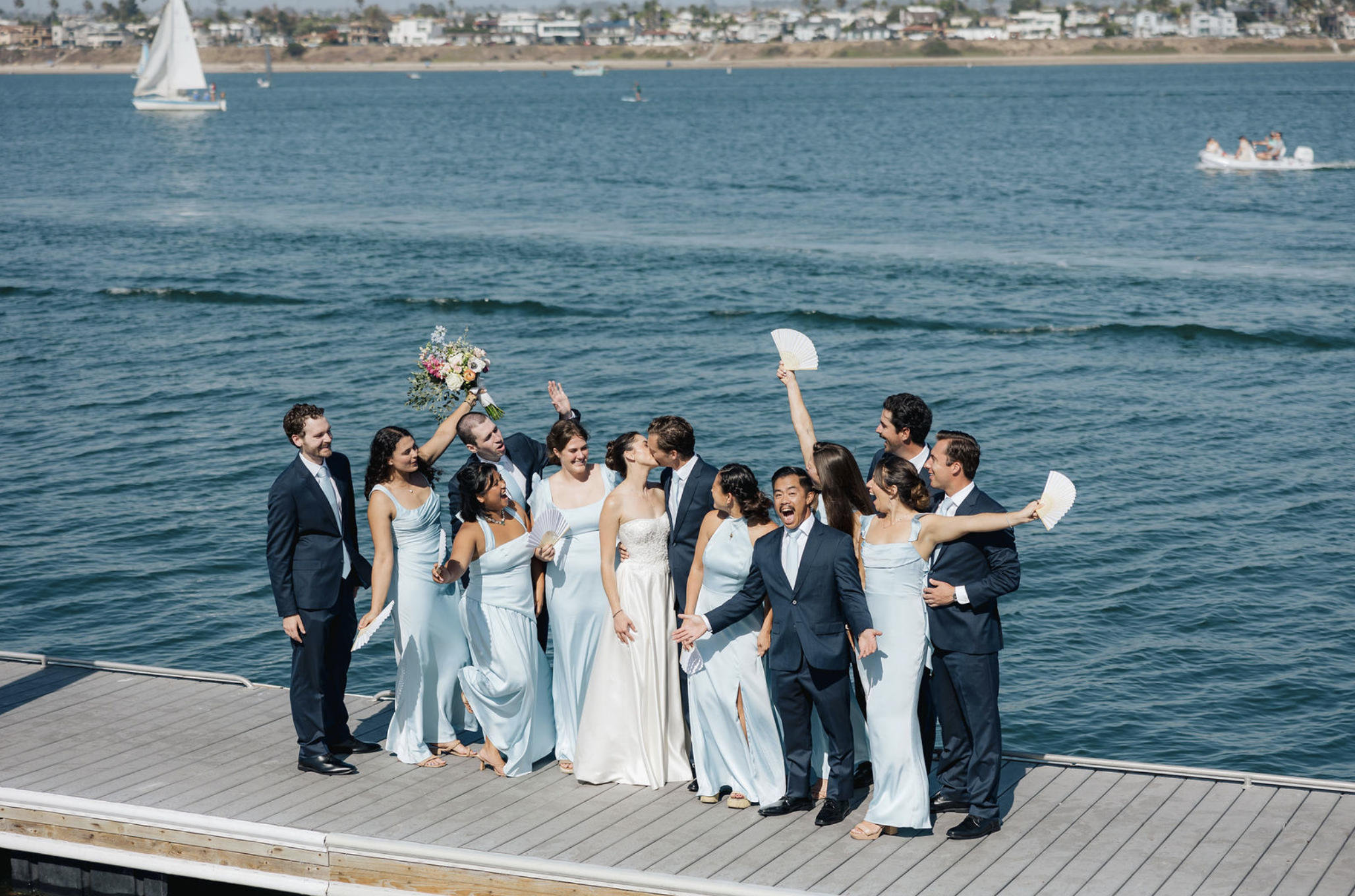 Beautiful bridal party and handsome groomsmen celebrating on docks of Mission Bay Yacht Club.