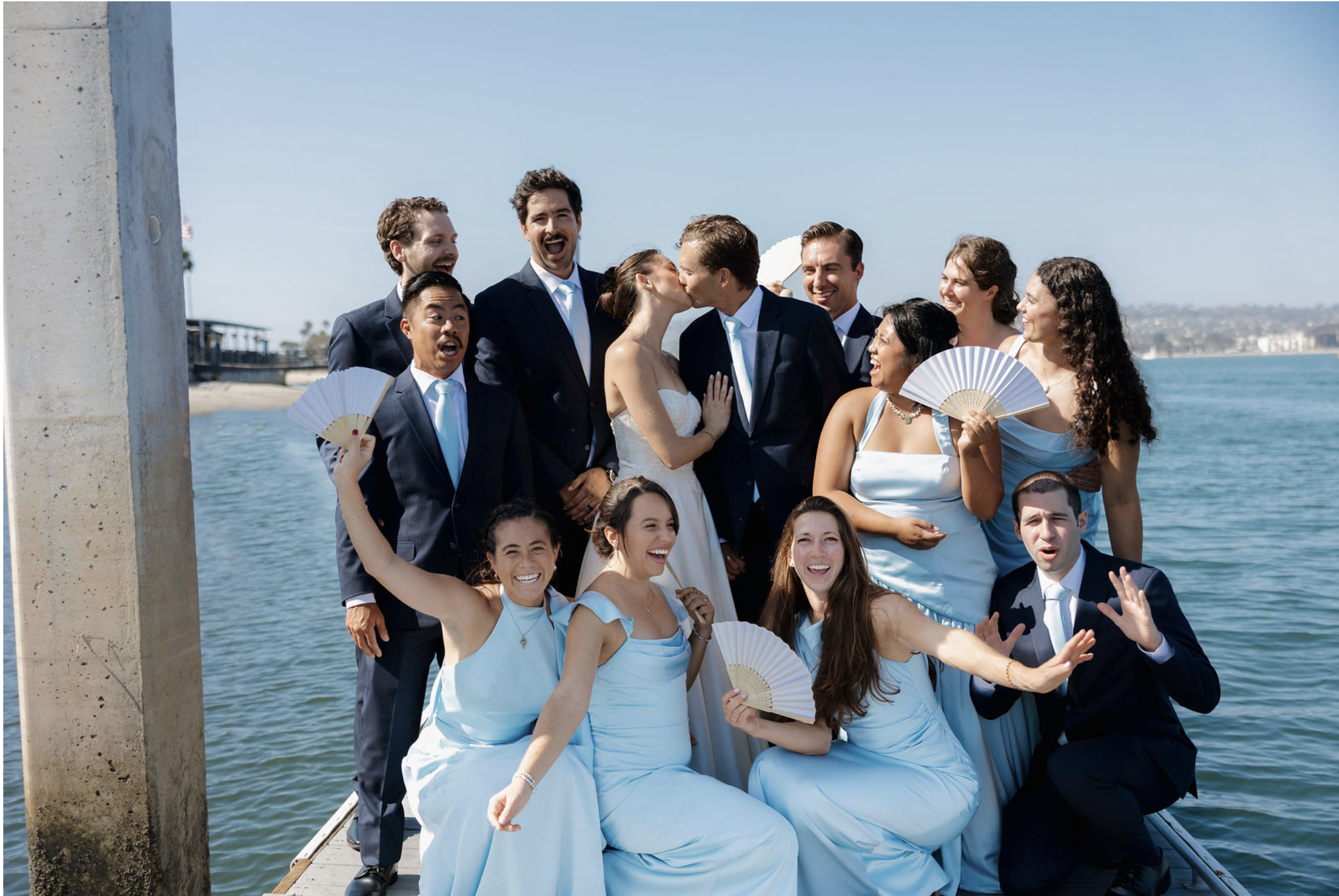 Beautiful bridal party and handsome groomsmen celebrating on docks of Mission Bay Yacht Club.